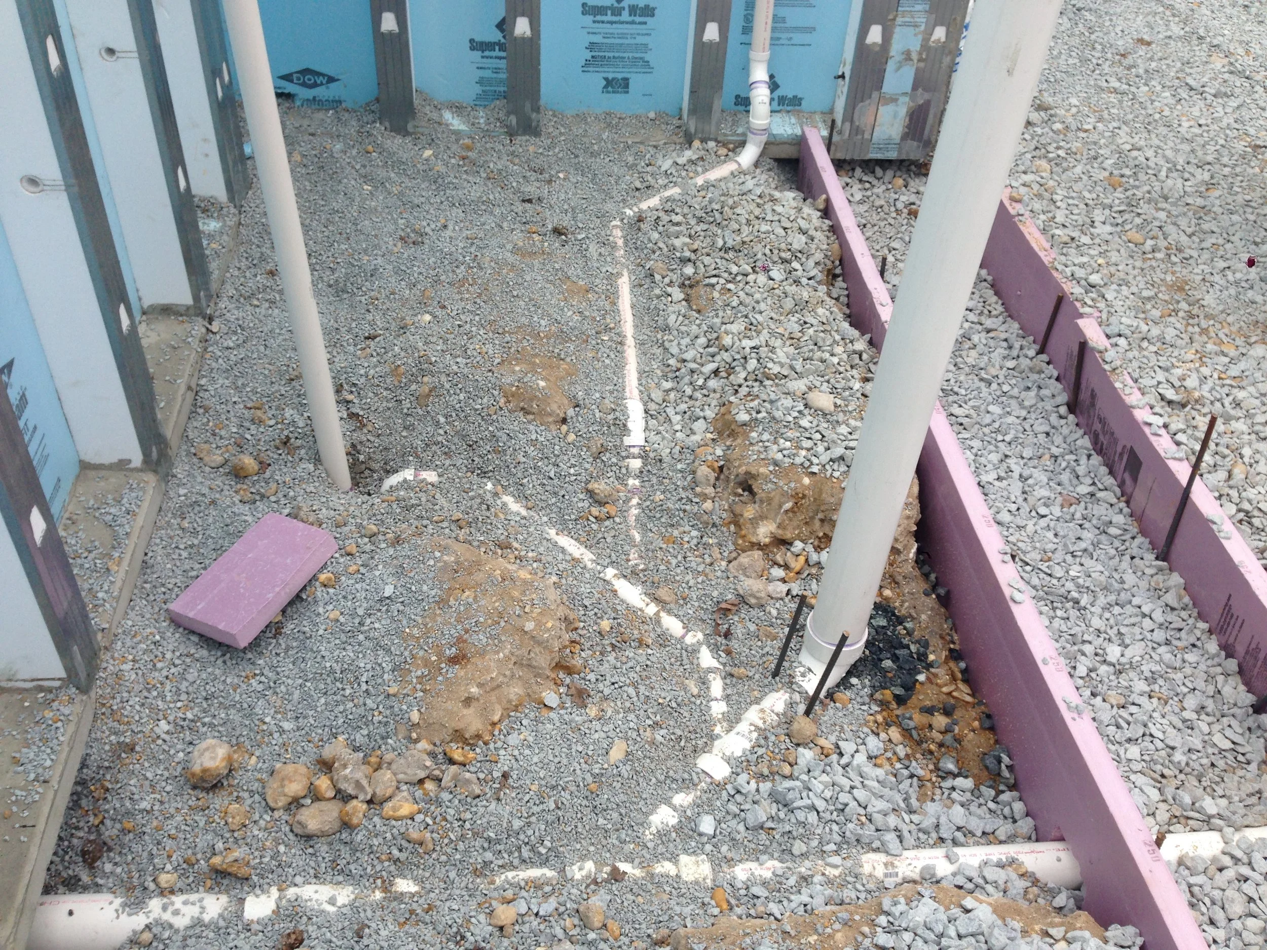 The rough plumbing is installed below grade with their p-traps and slopes.