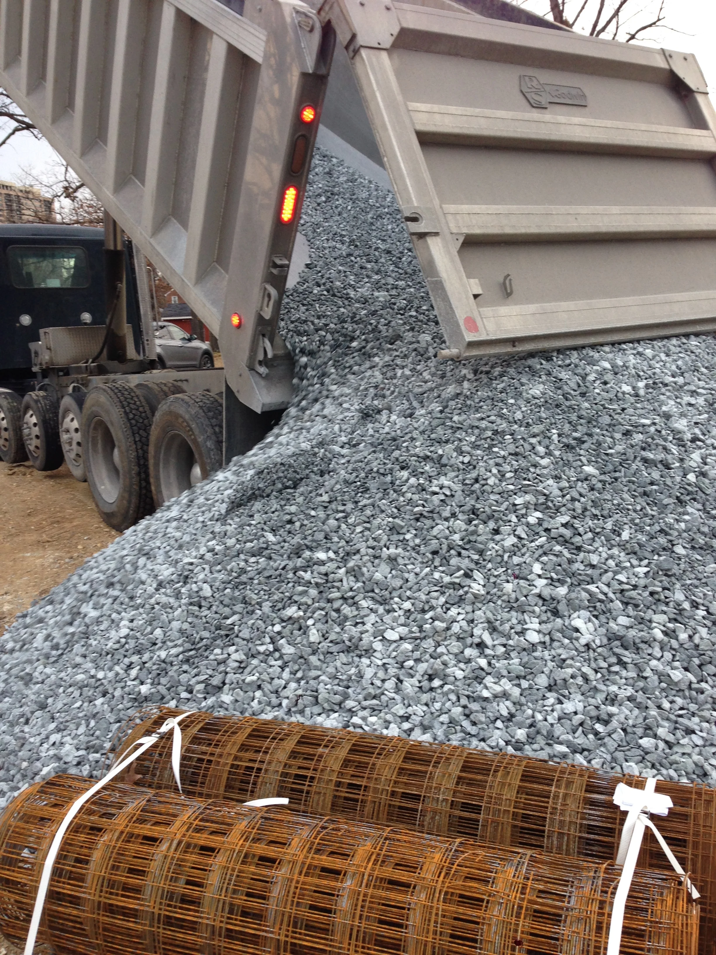 More gravel but this time #57 stone. Should be enough for the basement slab and the garage slab.