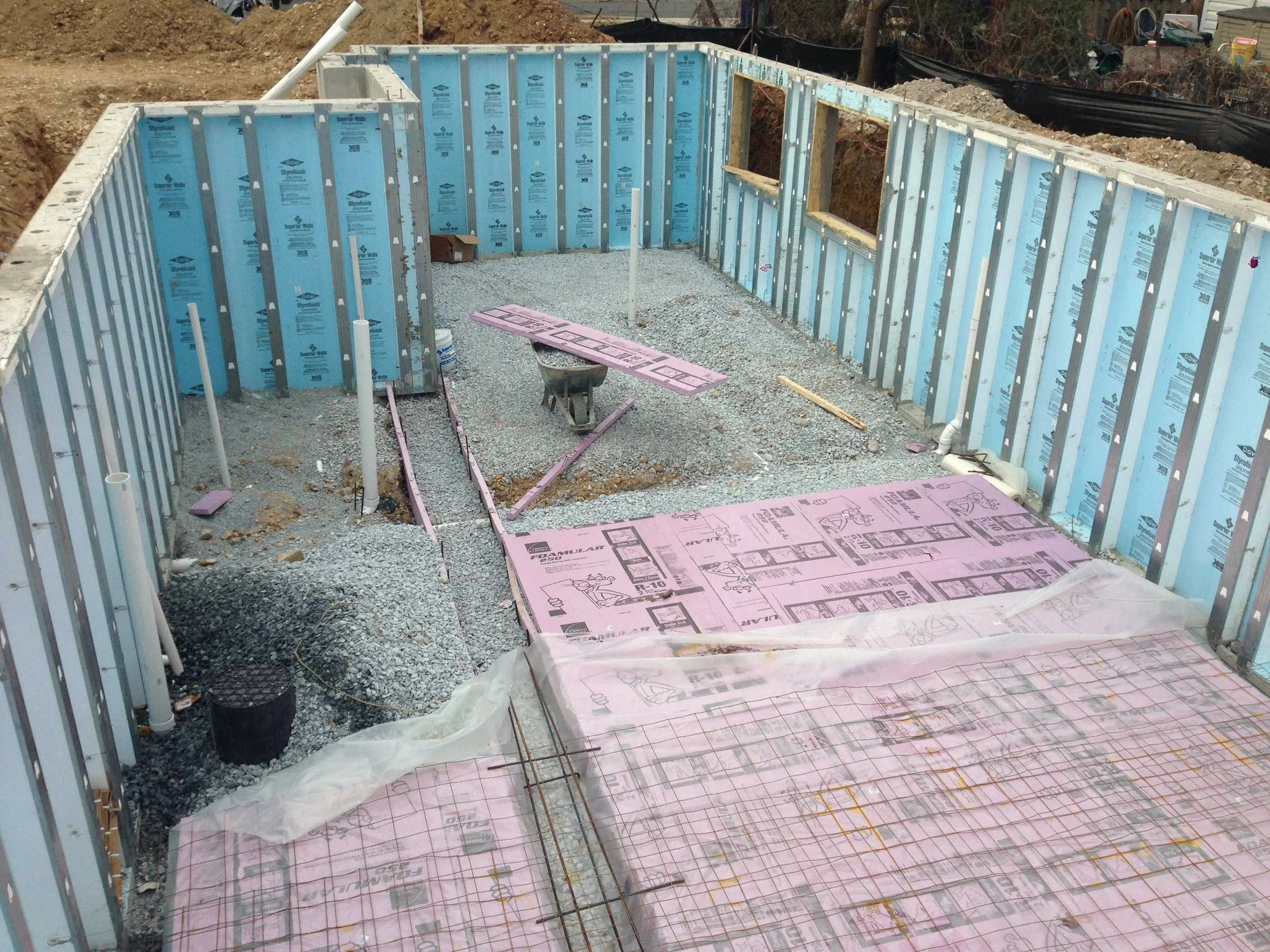 On schedule with the foundation. The pink and blue stuff is rigid insulation that will provide the floor with a nice consistent temperature throughout the year.