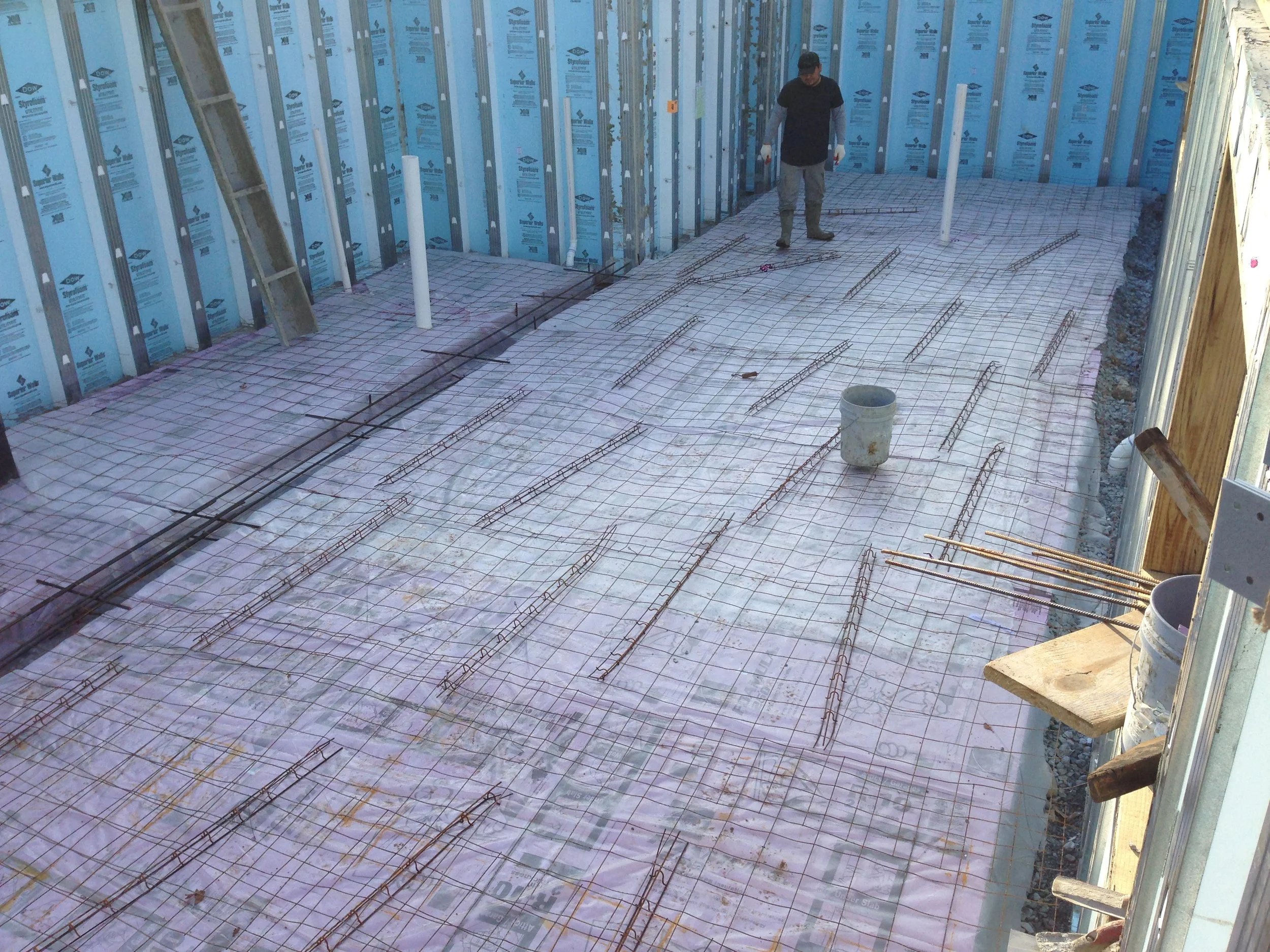 Those long looking things are the chairs. The help the wire mesh be a few inches off the ground. The wire mesh is tied to them so they don't float up in the concrete.
