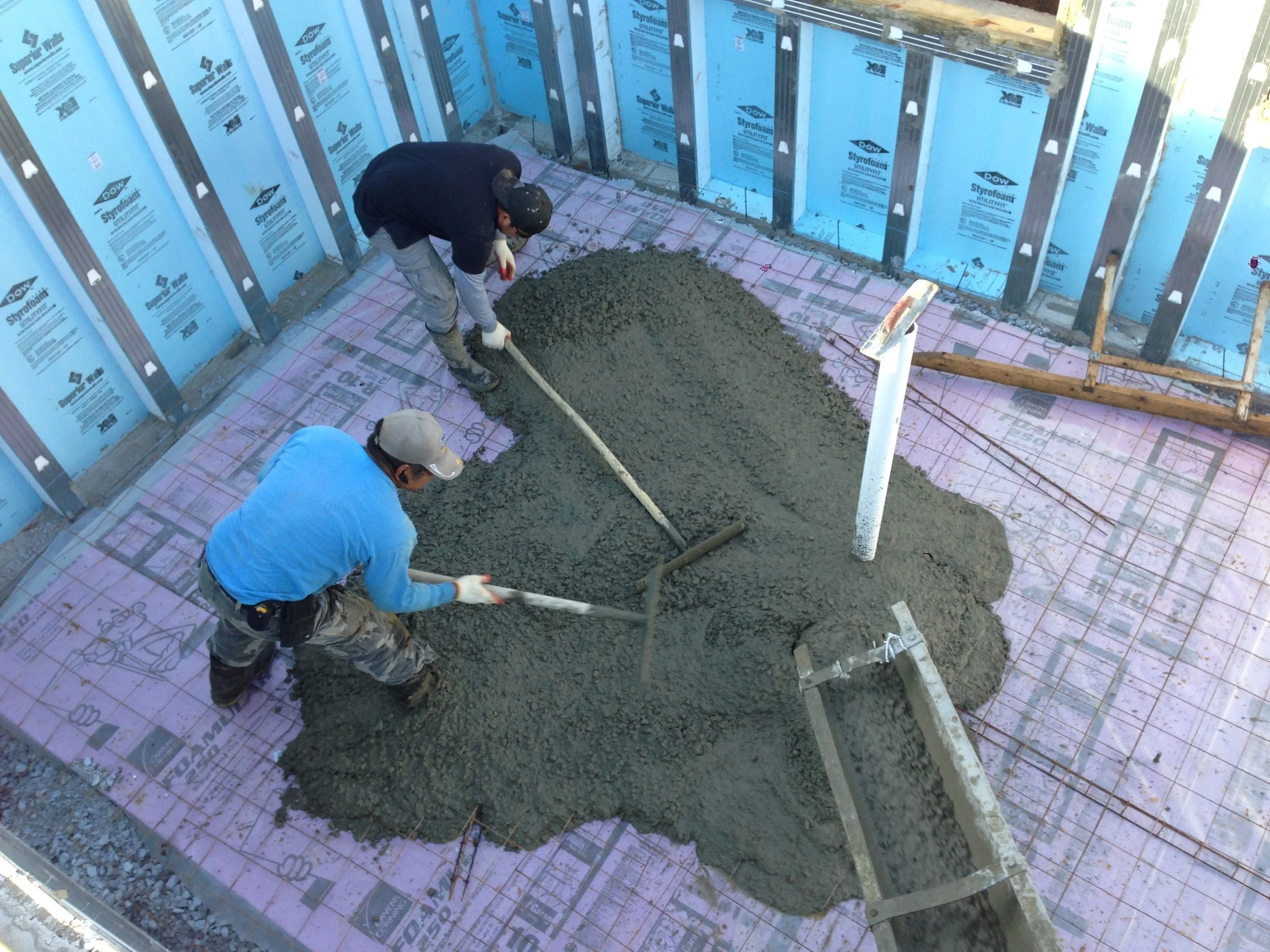 Jose and the guys got a good back workout spreading the concrete around. The concrete goes on top of a plastic called a vapor barrier which in turn lies on top of 2" of Rigid Insulation providing the slab with even temperature which sits on top of 4"-6" of compacted gravel which helps the underground water stay away from the slab.