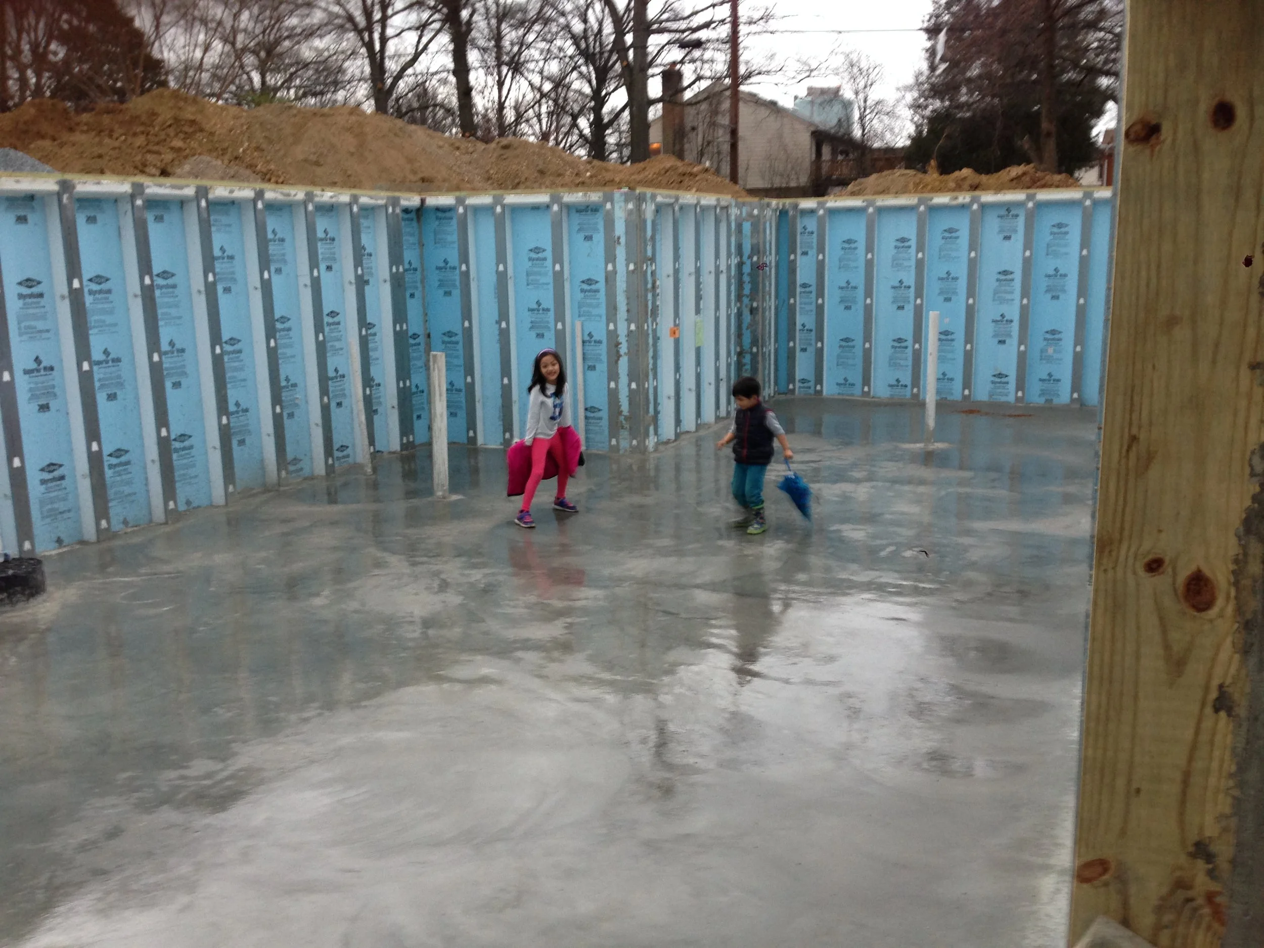 I knew the kids loved the mounds of dirt but an open slab with rain coming down is just as entertaining. The 20 minute storm caused the framers to delay the walls until Monday. 