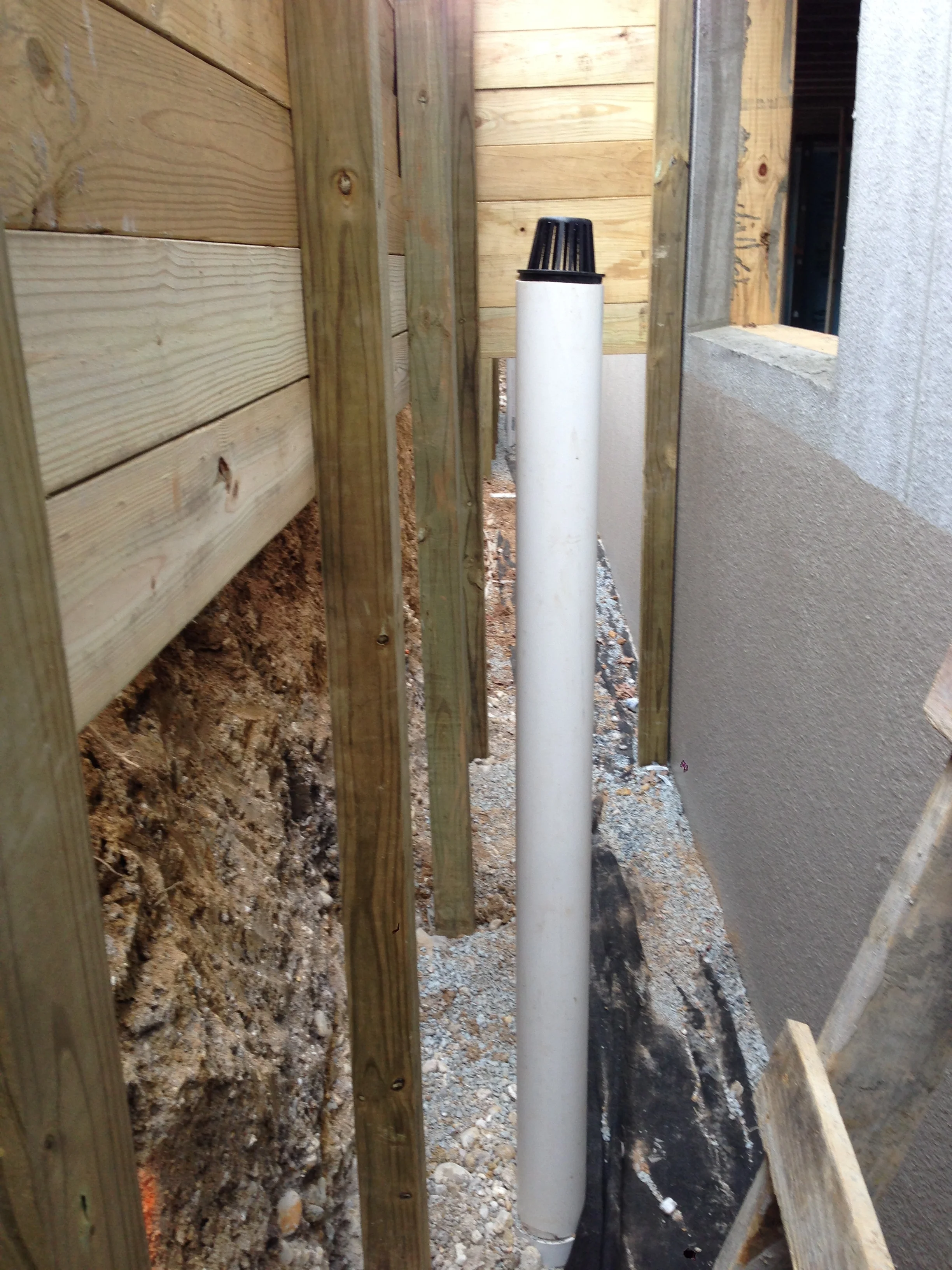 Drain extending to where the window well will be located to the below grade drain. Water is a basement #1 enemy and getting it out of the way ASAP is key. Also, notice the great waterproofing that will protect my walls for eons.
