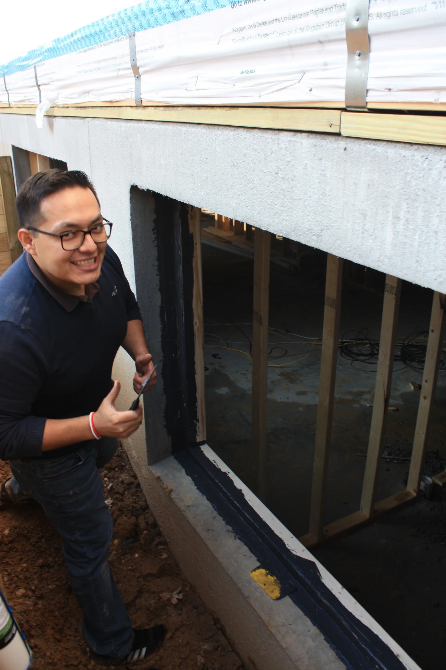 Juan Sebastian doing his best not to get too dirty while working with very sticky liquid applied flashing.