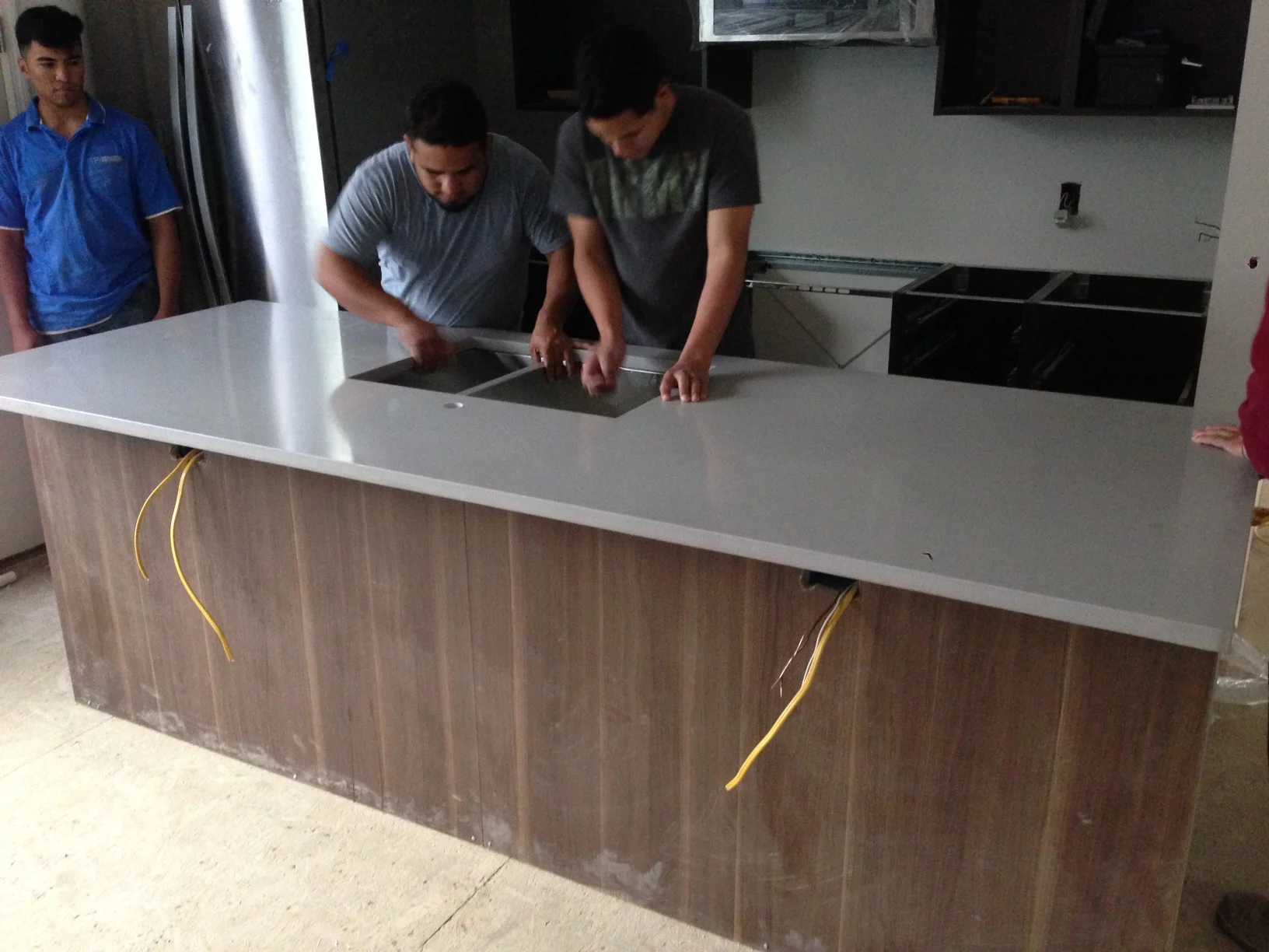 The undermount sink being installed with the counter top. Looking nice.