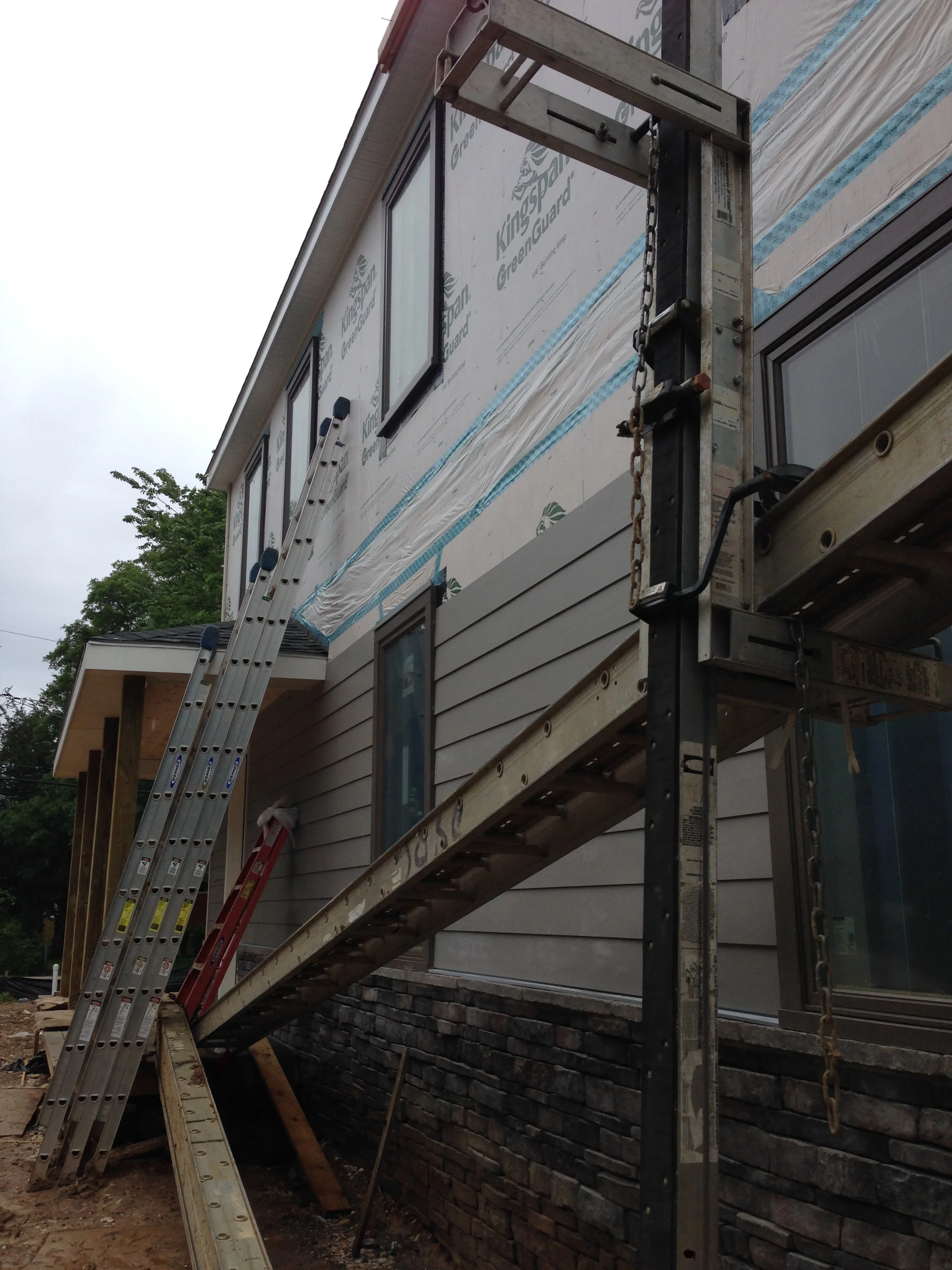 Siding continuing to go up and wrapping around the front.