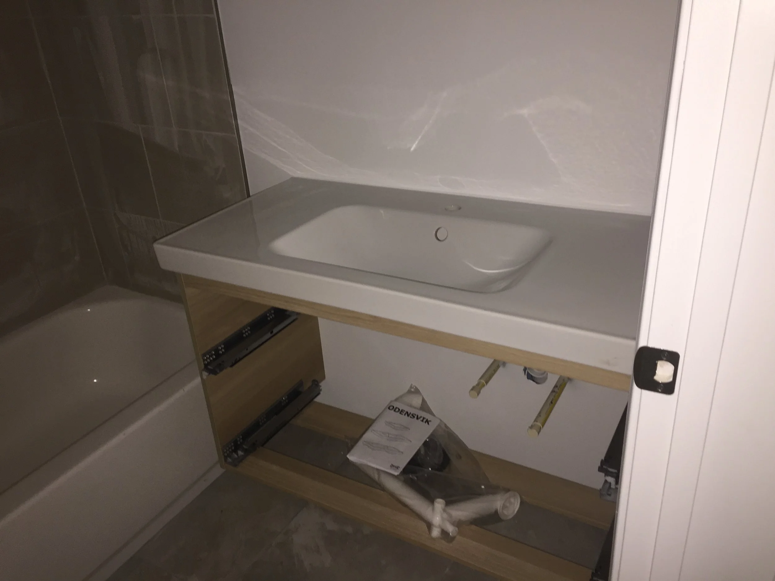 Basement bathroom vanity installed with the new IKEA piece holding up the counter. 