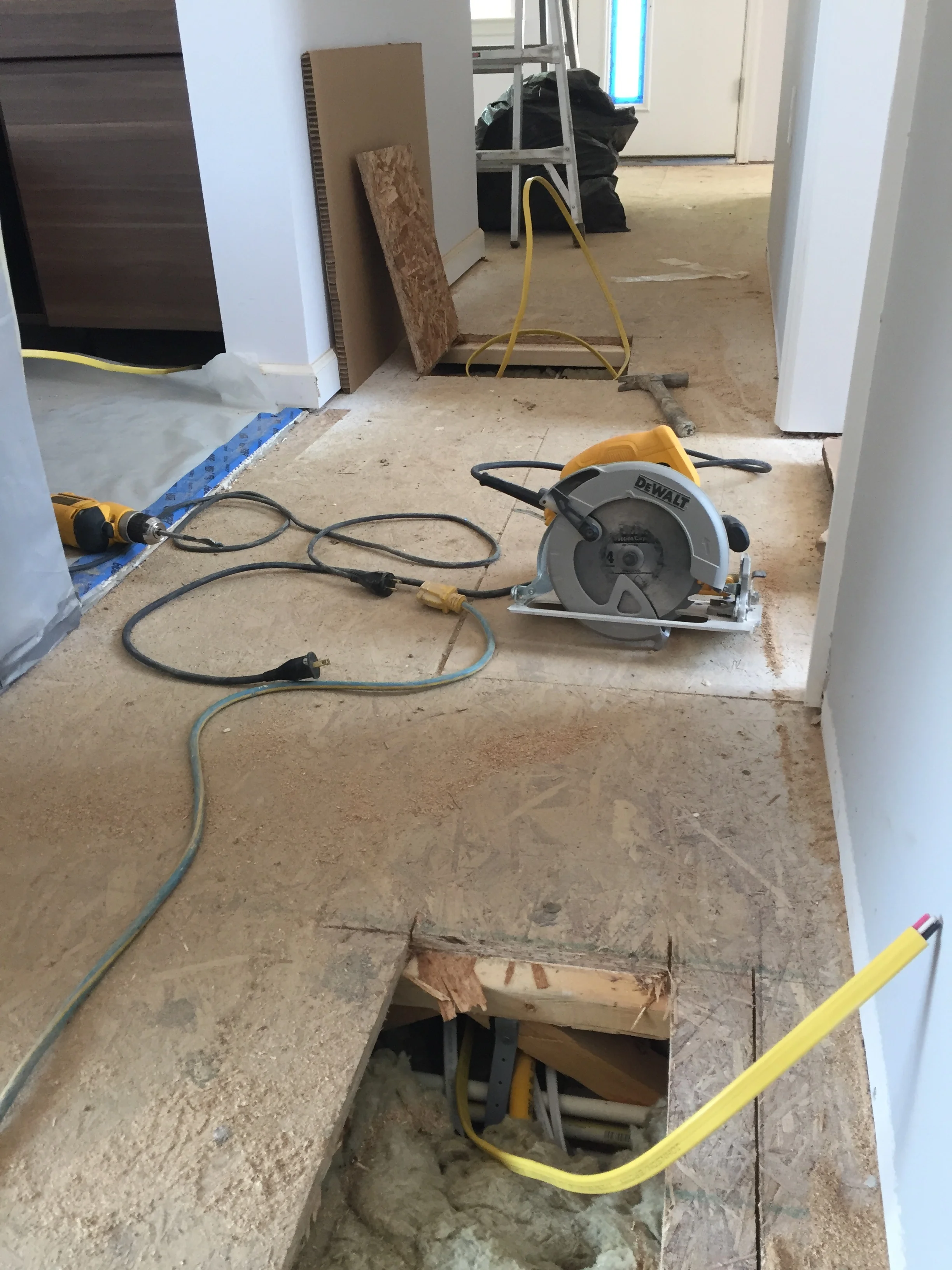 The wire starts at the top left of the photo below the kitchen cabinets. It then snakes it was under the wall and pops up at the top center of the photo. Then the wire travels to the bottom of the photo where it will go to the right of the photo under the floor and into the basement mechanical room. I am glad the wire was hard enough that we could snake it through the floor joists. I'm really glad they gave us open floor joists!!!