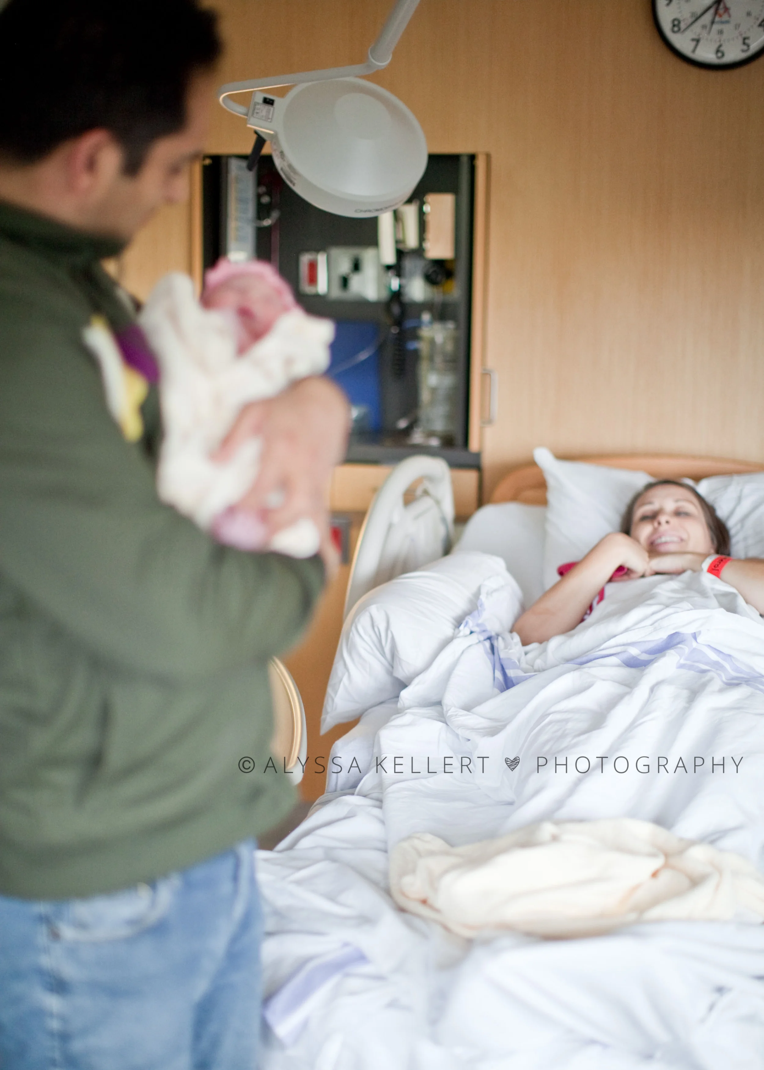 photography-newborn-photography-birth-story-dad-hold-baby-mom-background-labour-peace-arch-hospital