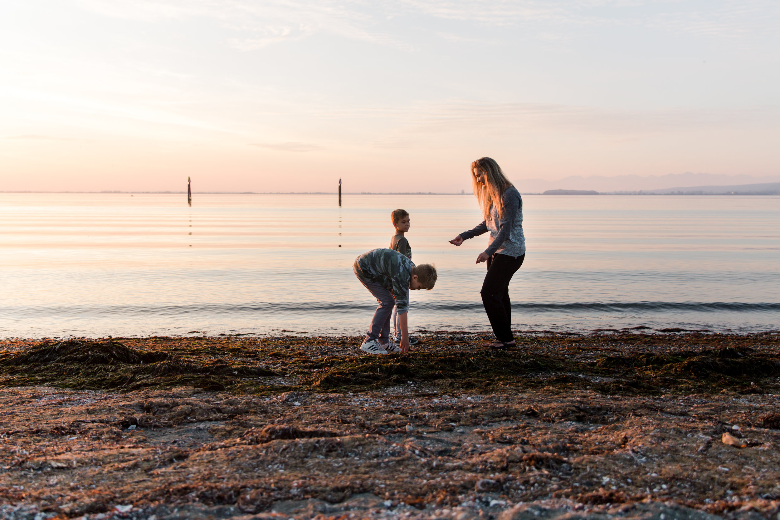 mom with boys on the beach in south surrey throwing rocks