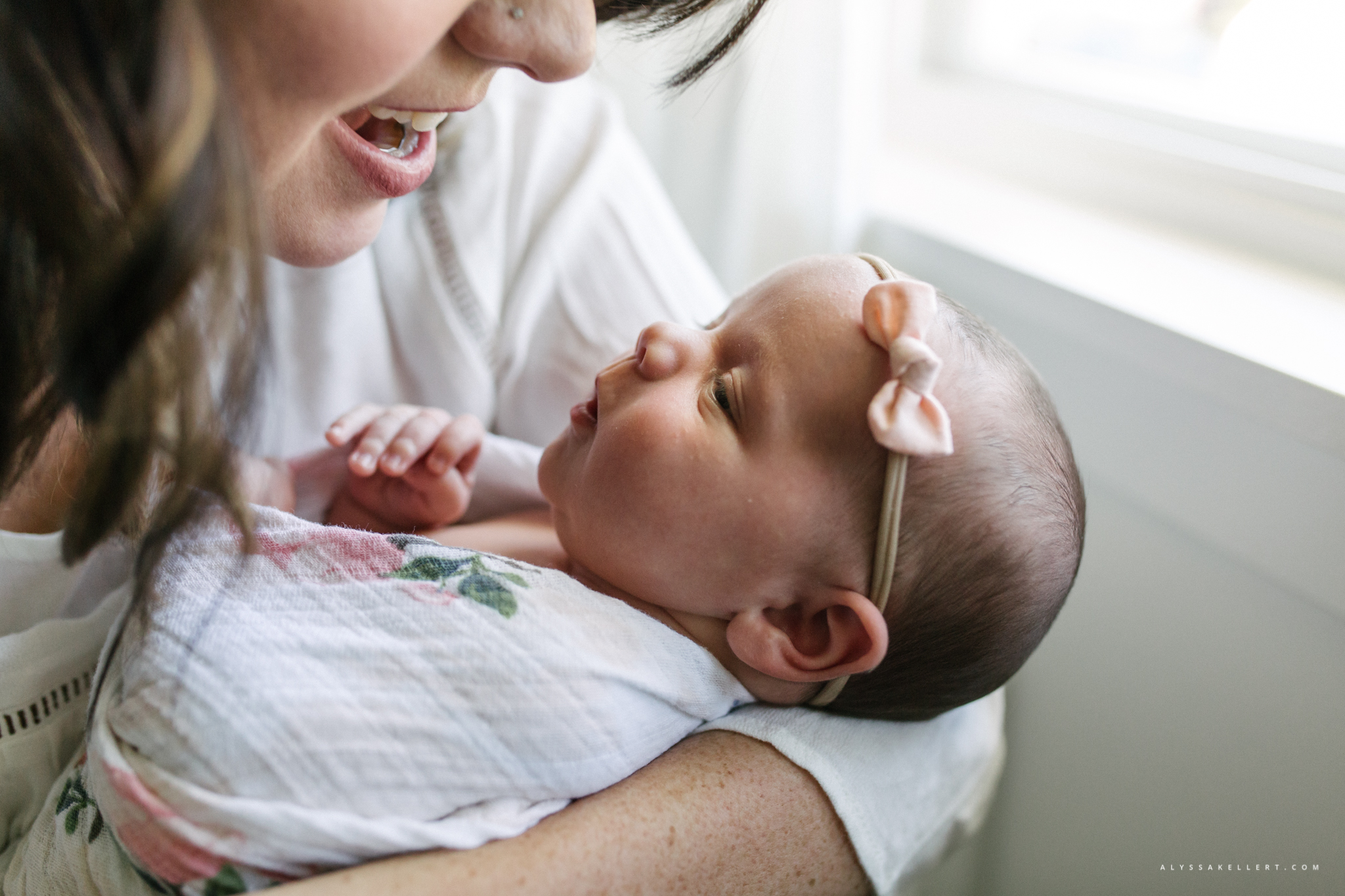 mom looking down at her baby newborn girl smiling photography