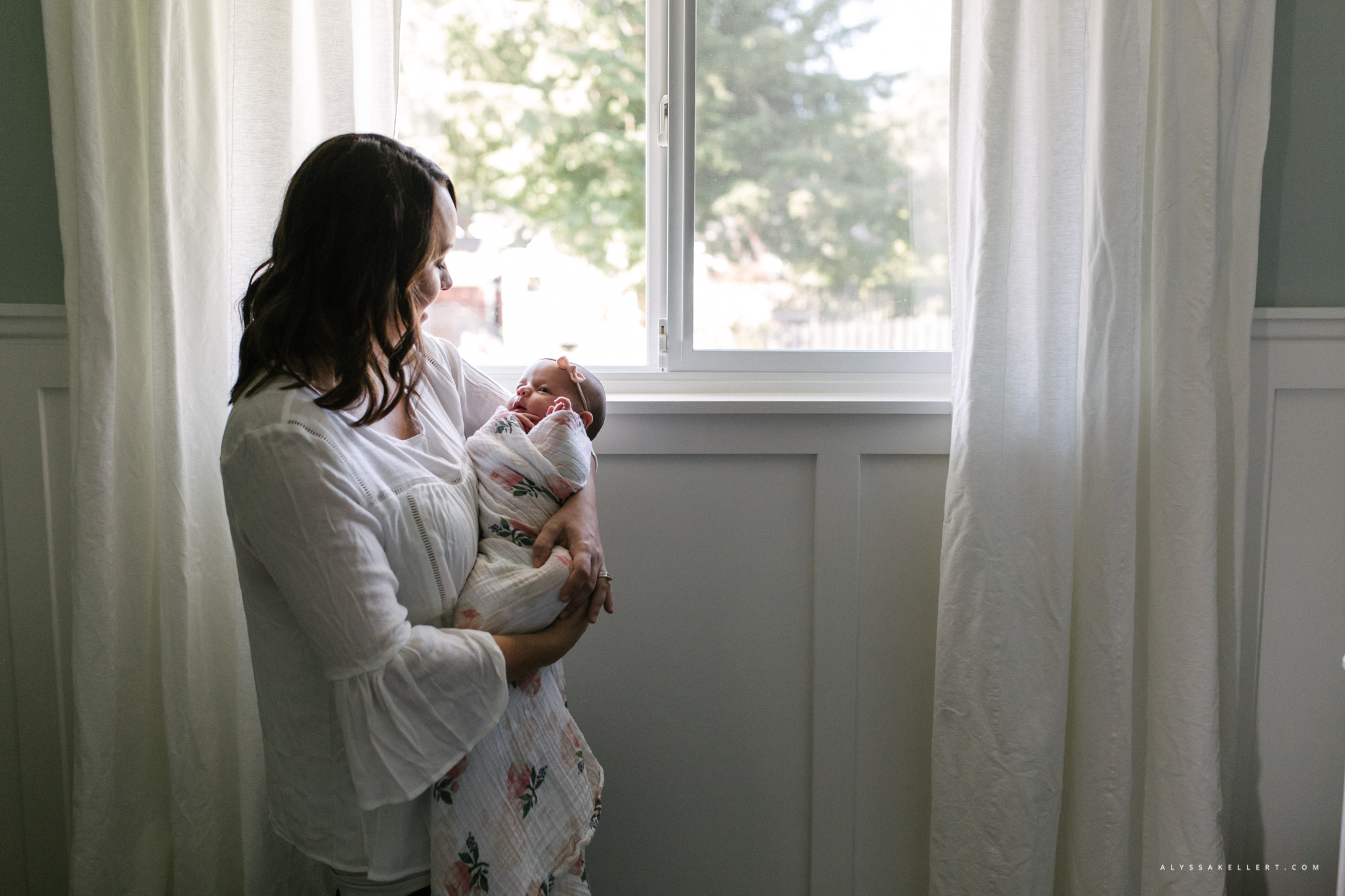 mom and baby girl by window