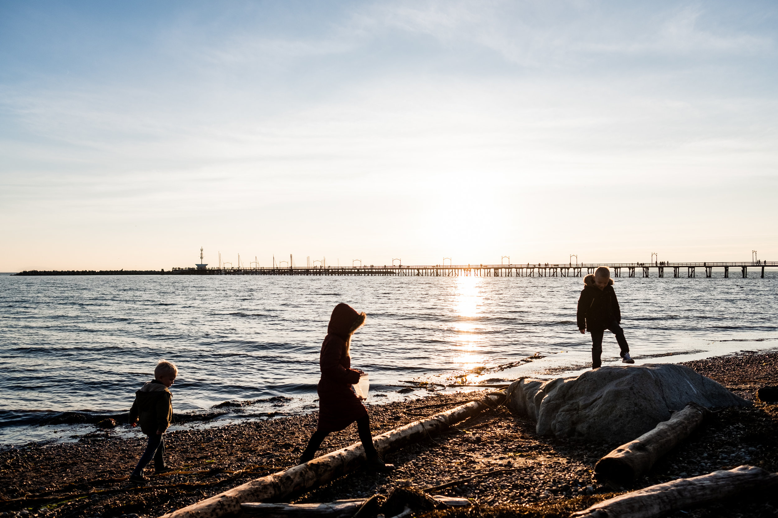kids on cold beach at sunset white rock pier