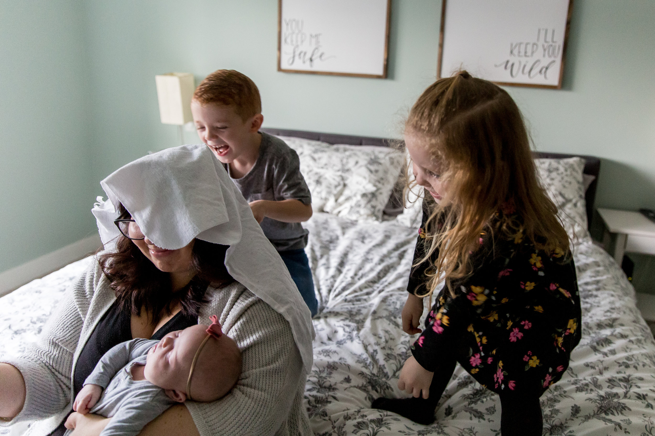 kids throwing blanket on moms head with newborn vancouver