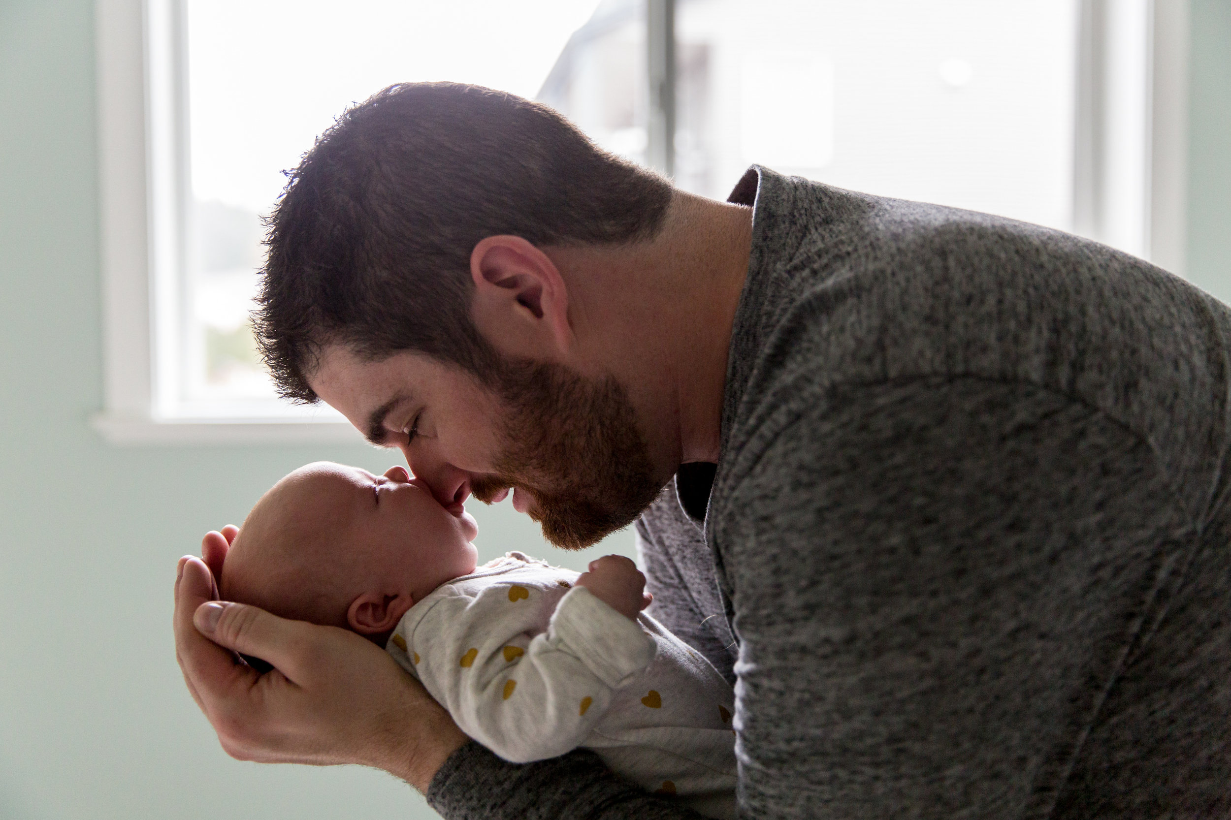 dad and baby on bed by window vancouver