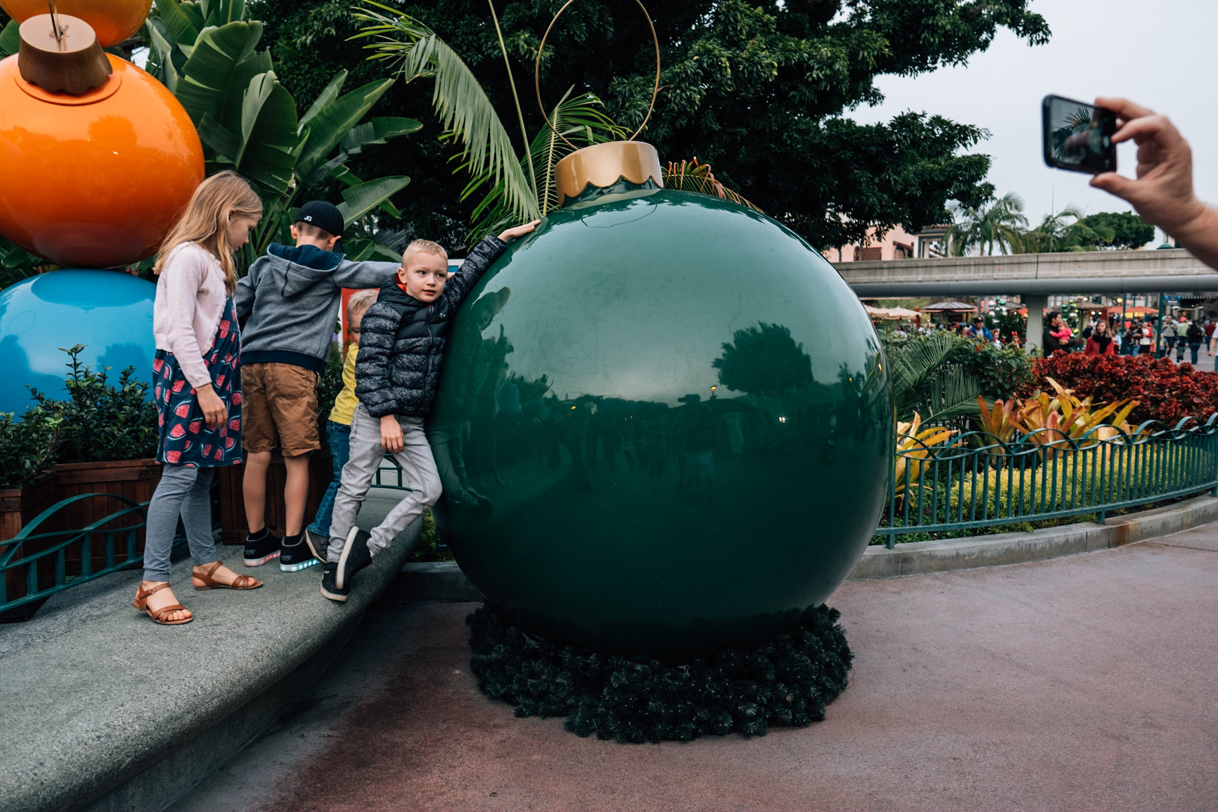 kids with giant christmas bulb at downtown disney