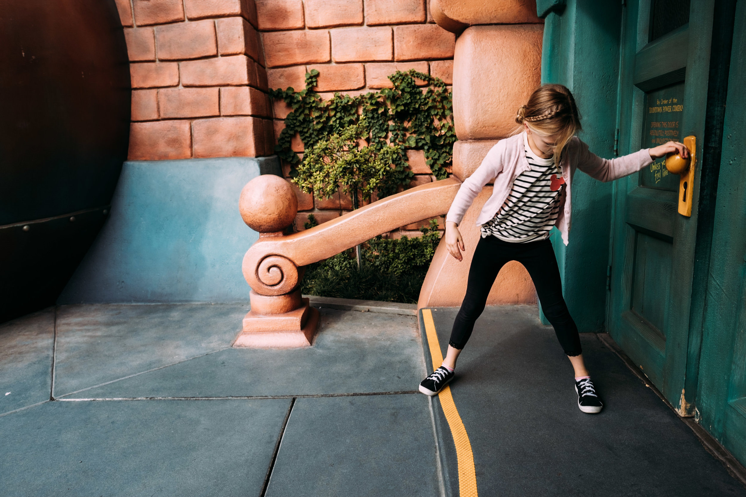 girl pulling on door knob at disneyland