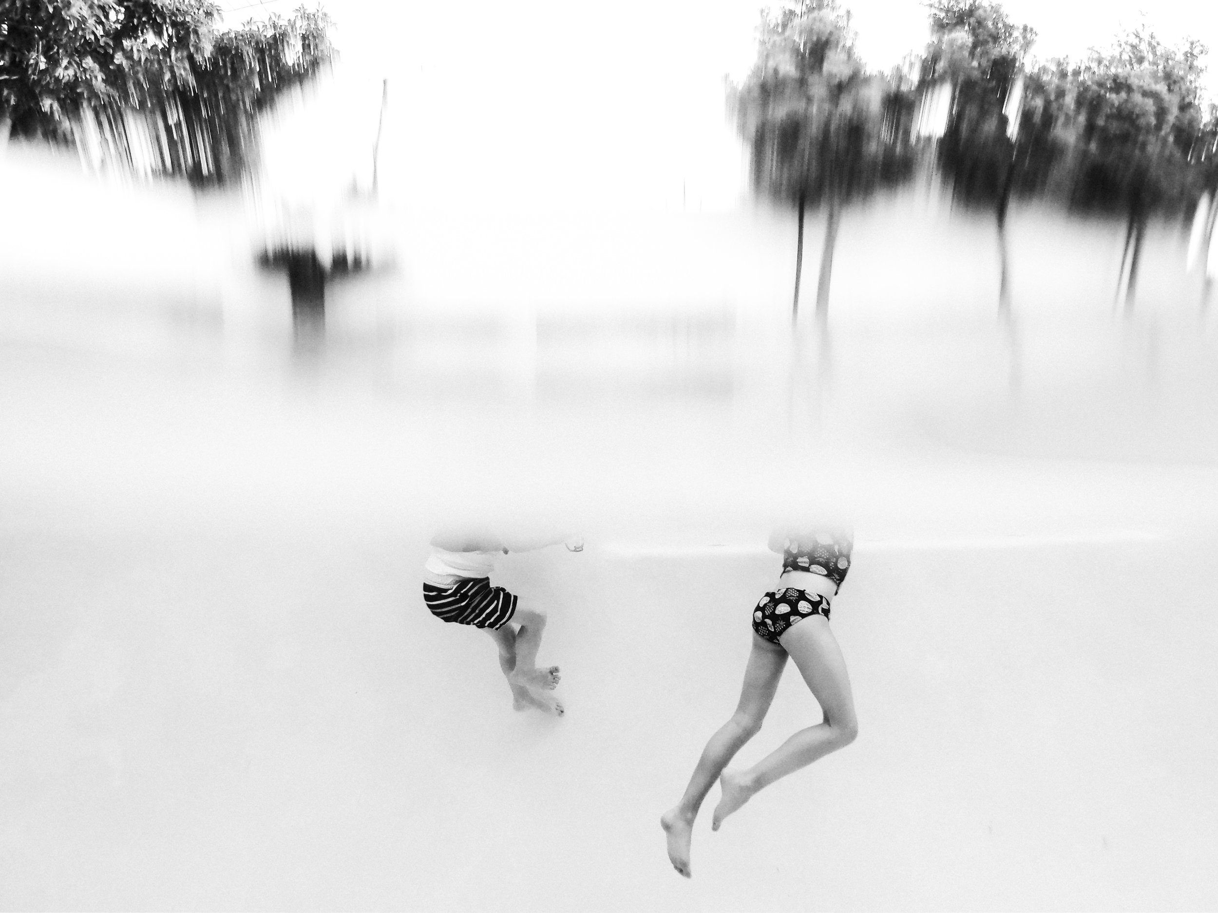 bottom half of kids swimming underwater