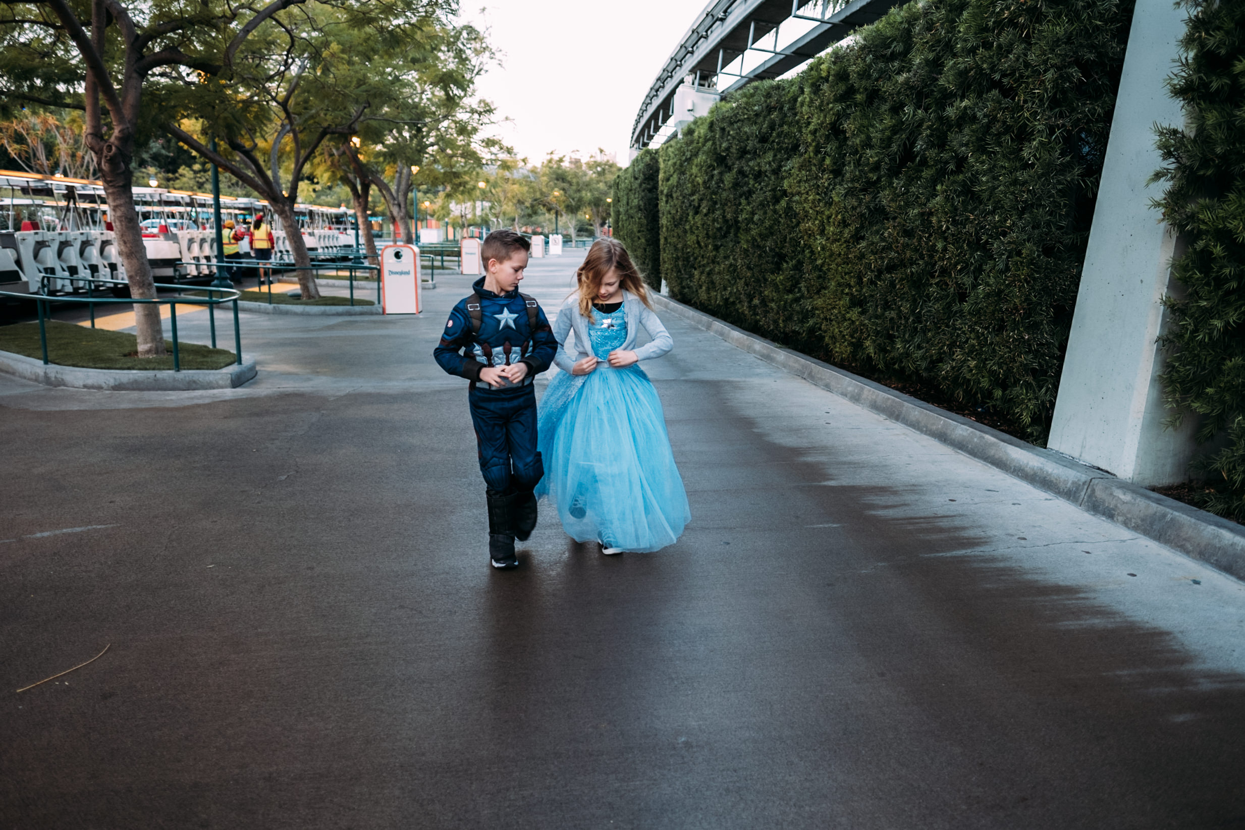 kids walking and talking wearing princess and captain america costume