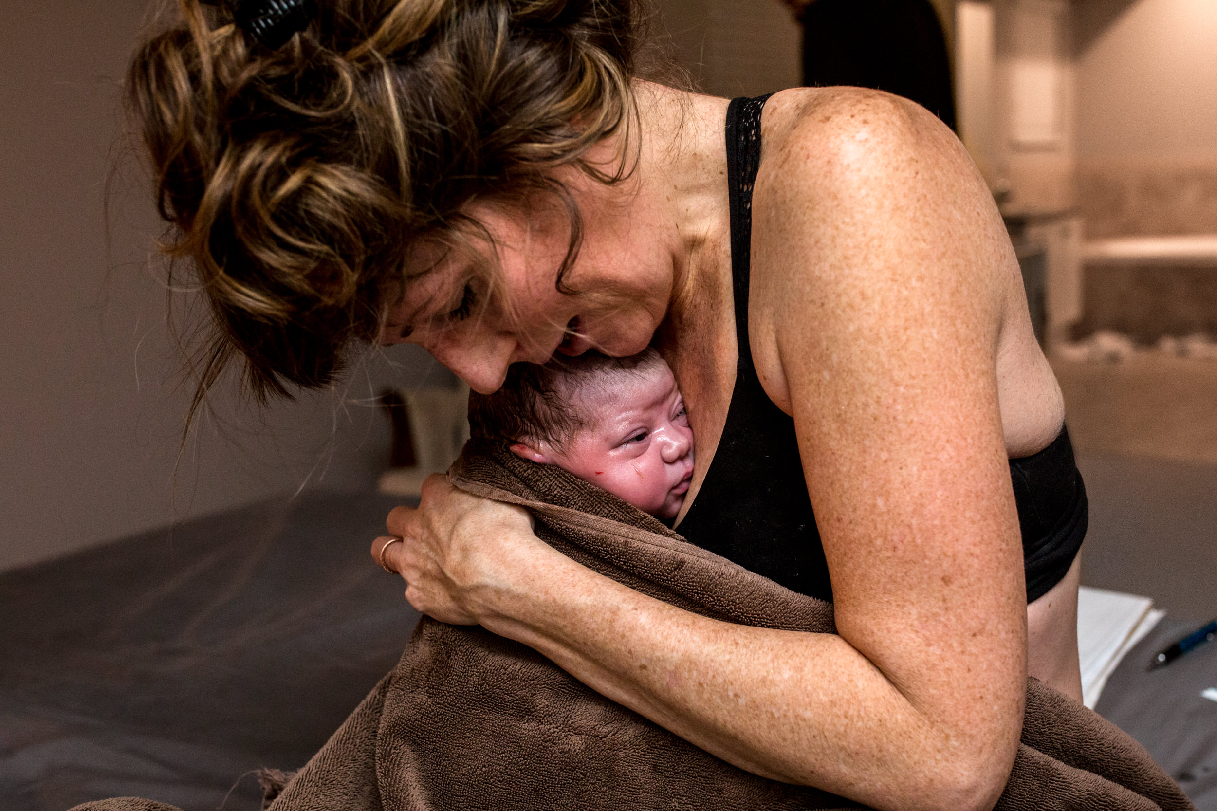 mom holding her newborn baby after delivery