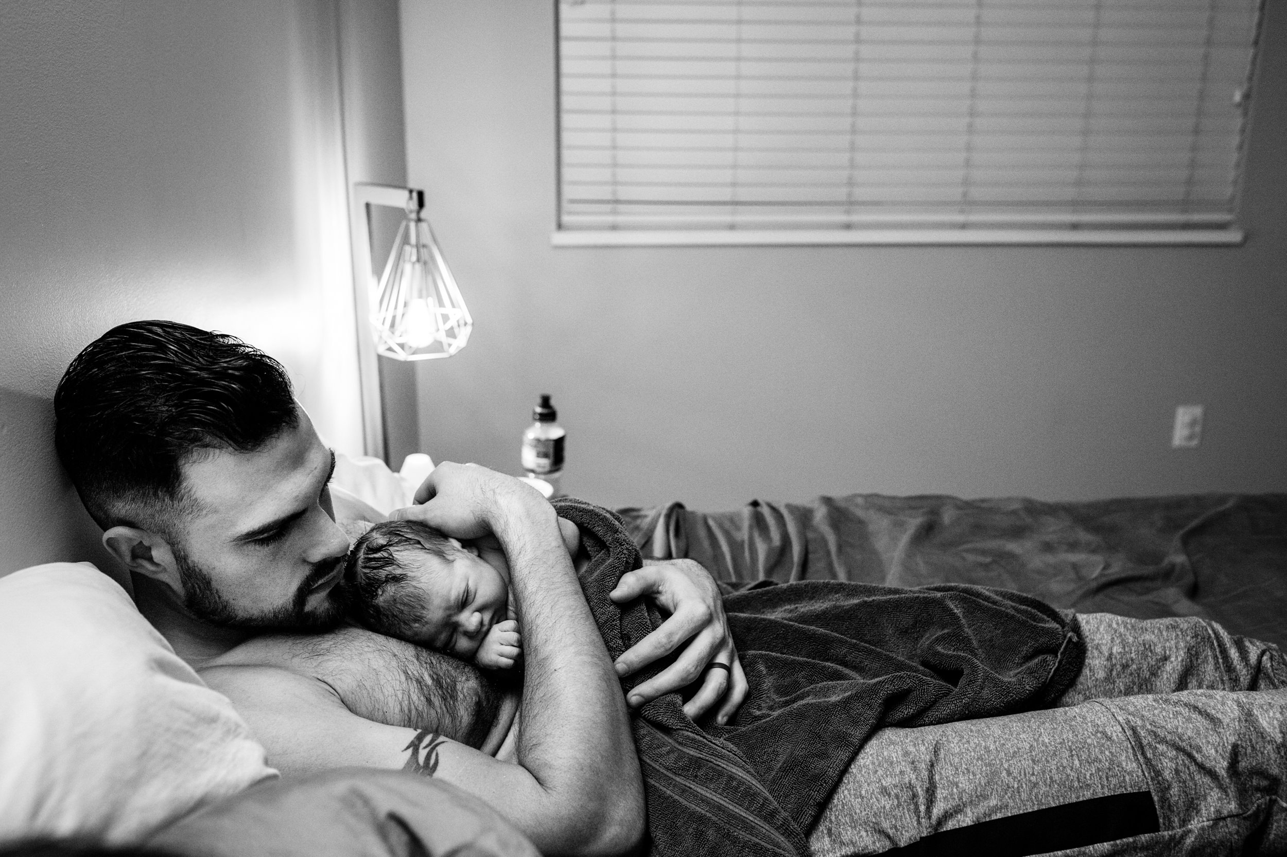 dad holding baby on chest black and white
