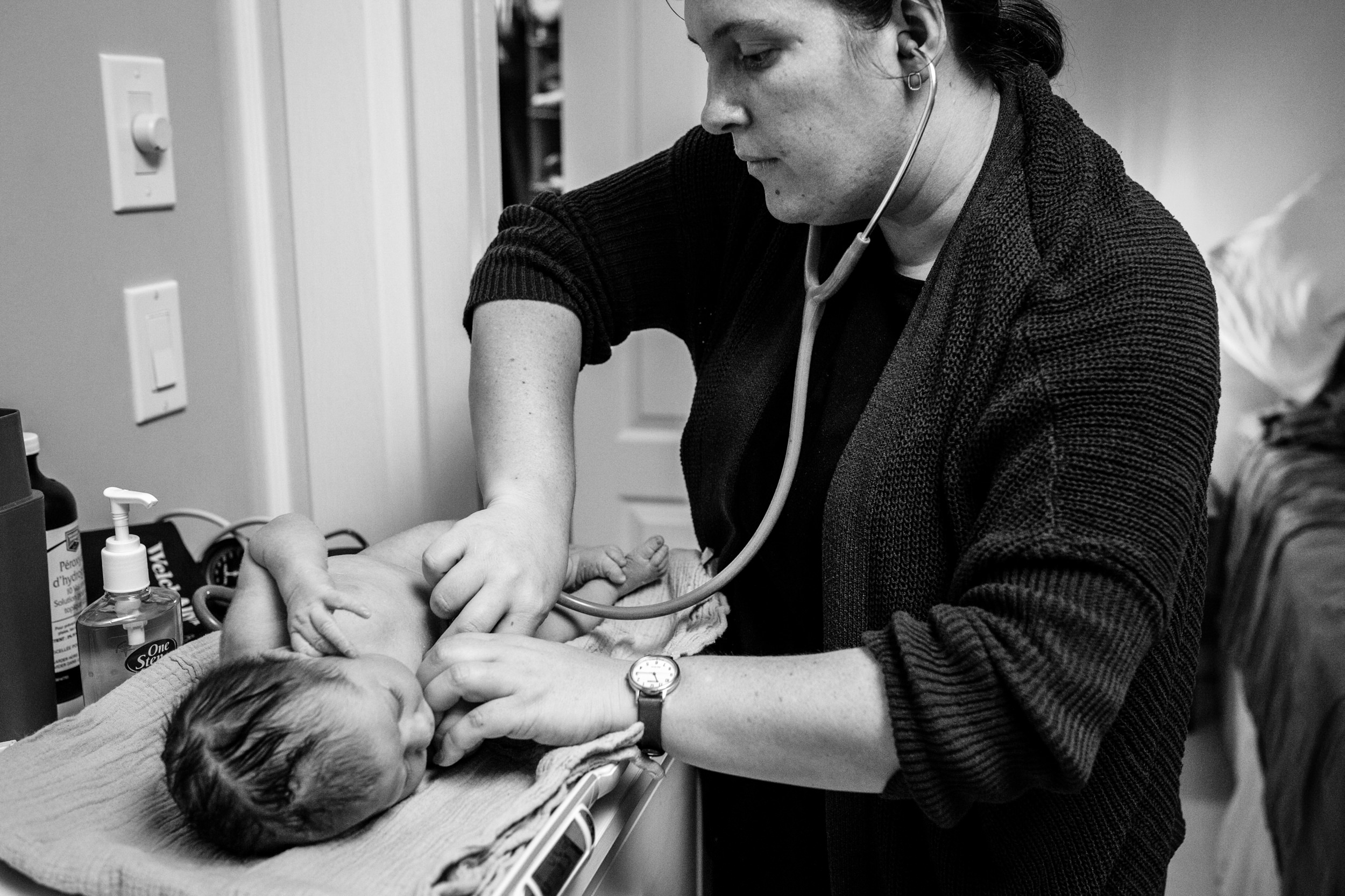 midwife giving newborn baby a health check