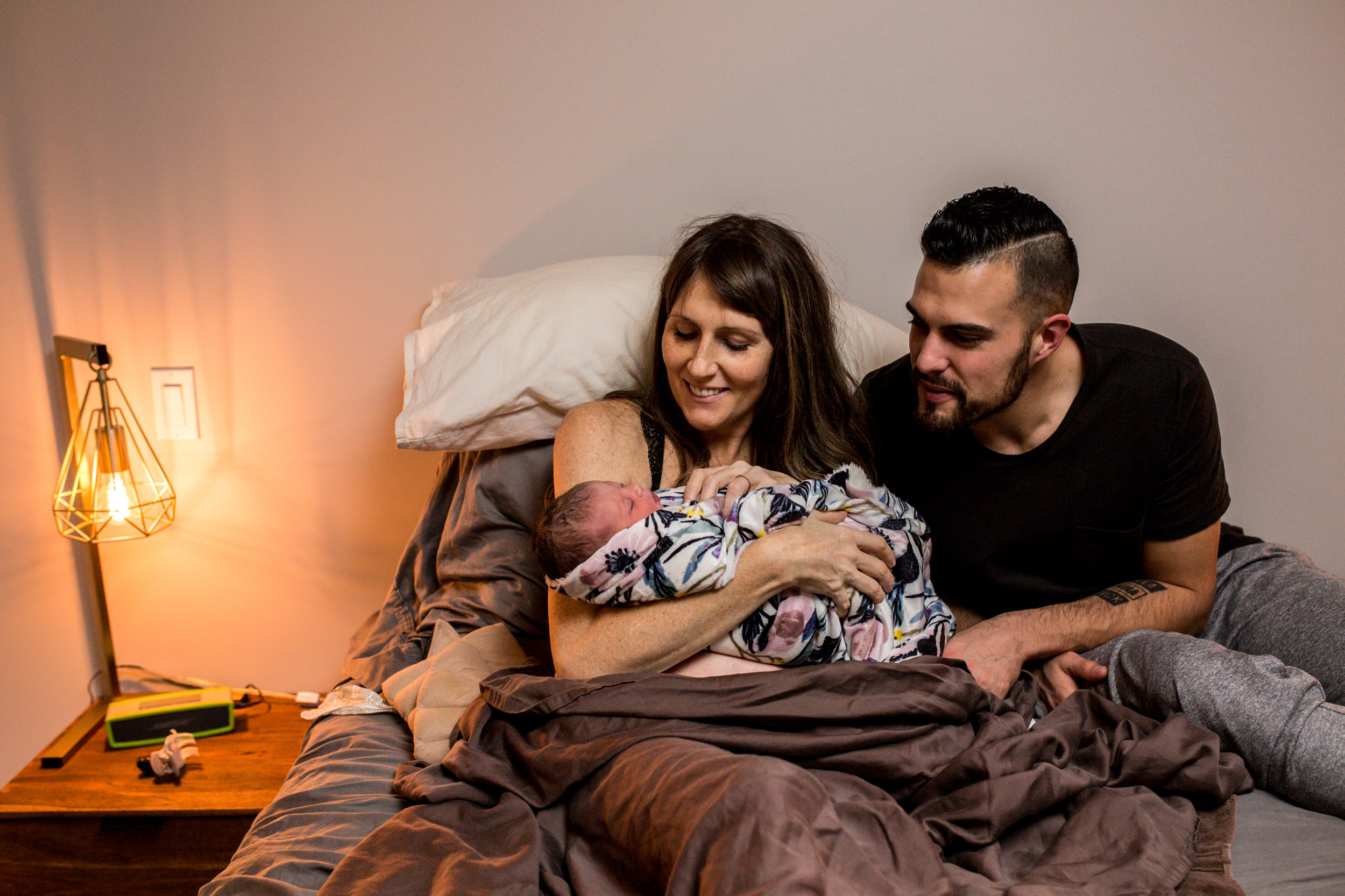 parents with newborn on bed