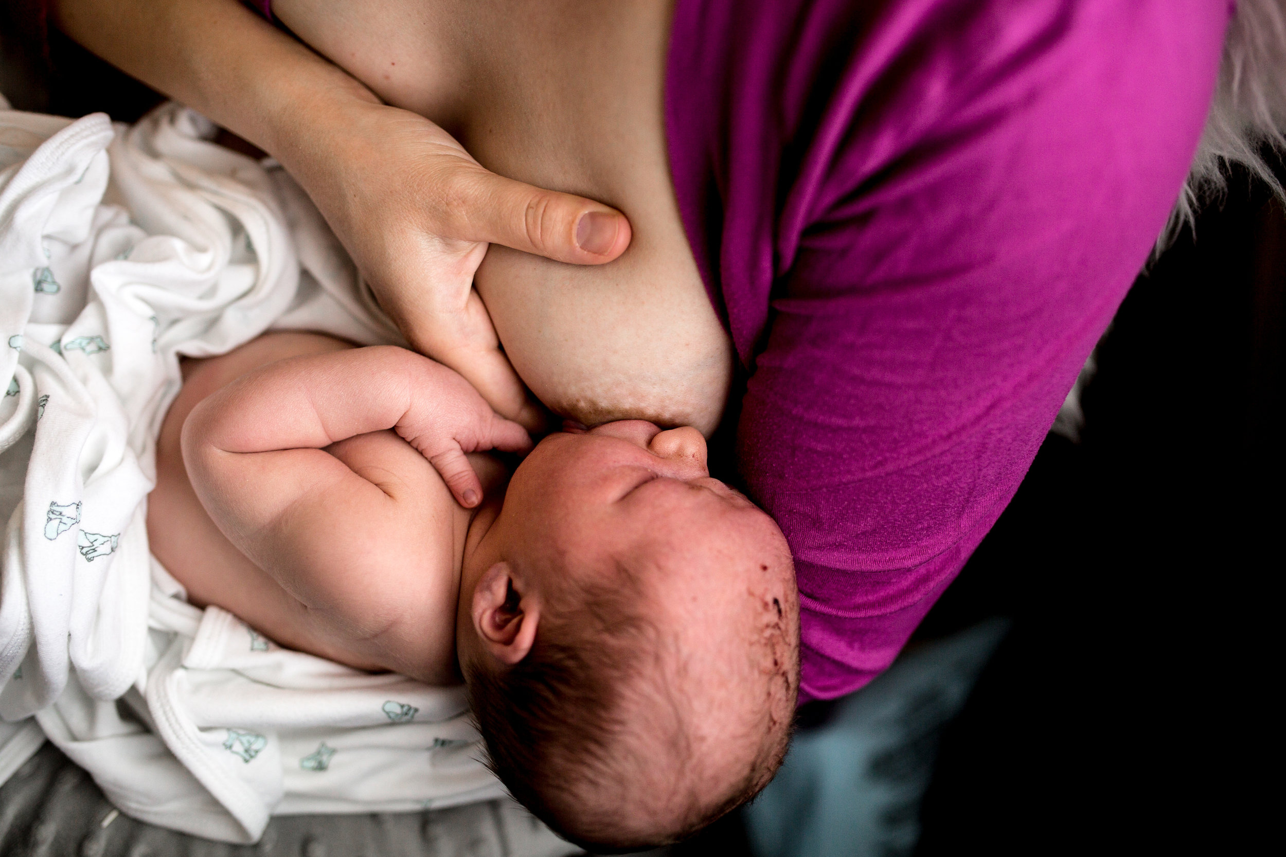 mom doing breast compressions while nursing her baby