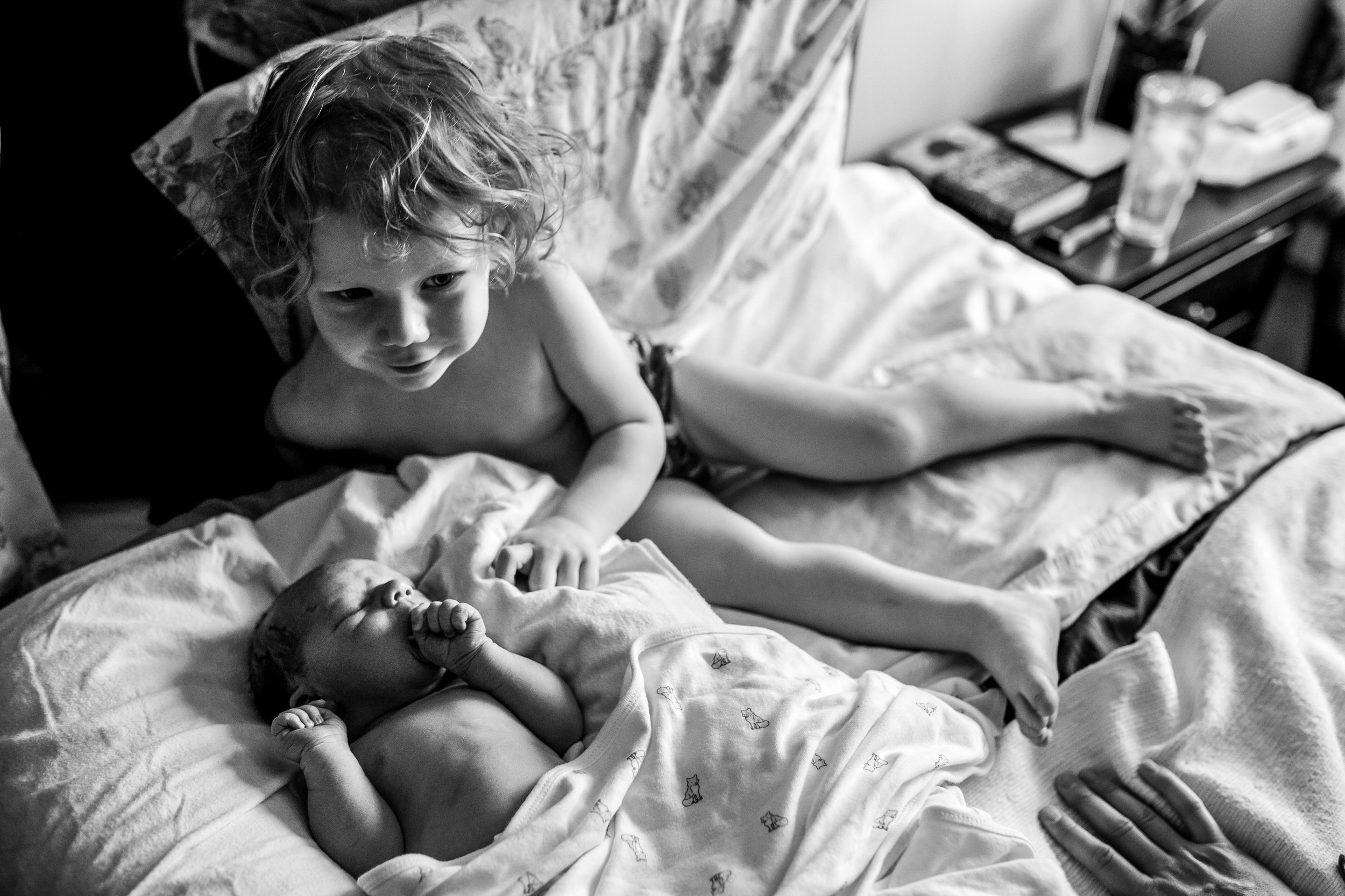 brothers on the bed together, one is a newborn