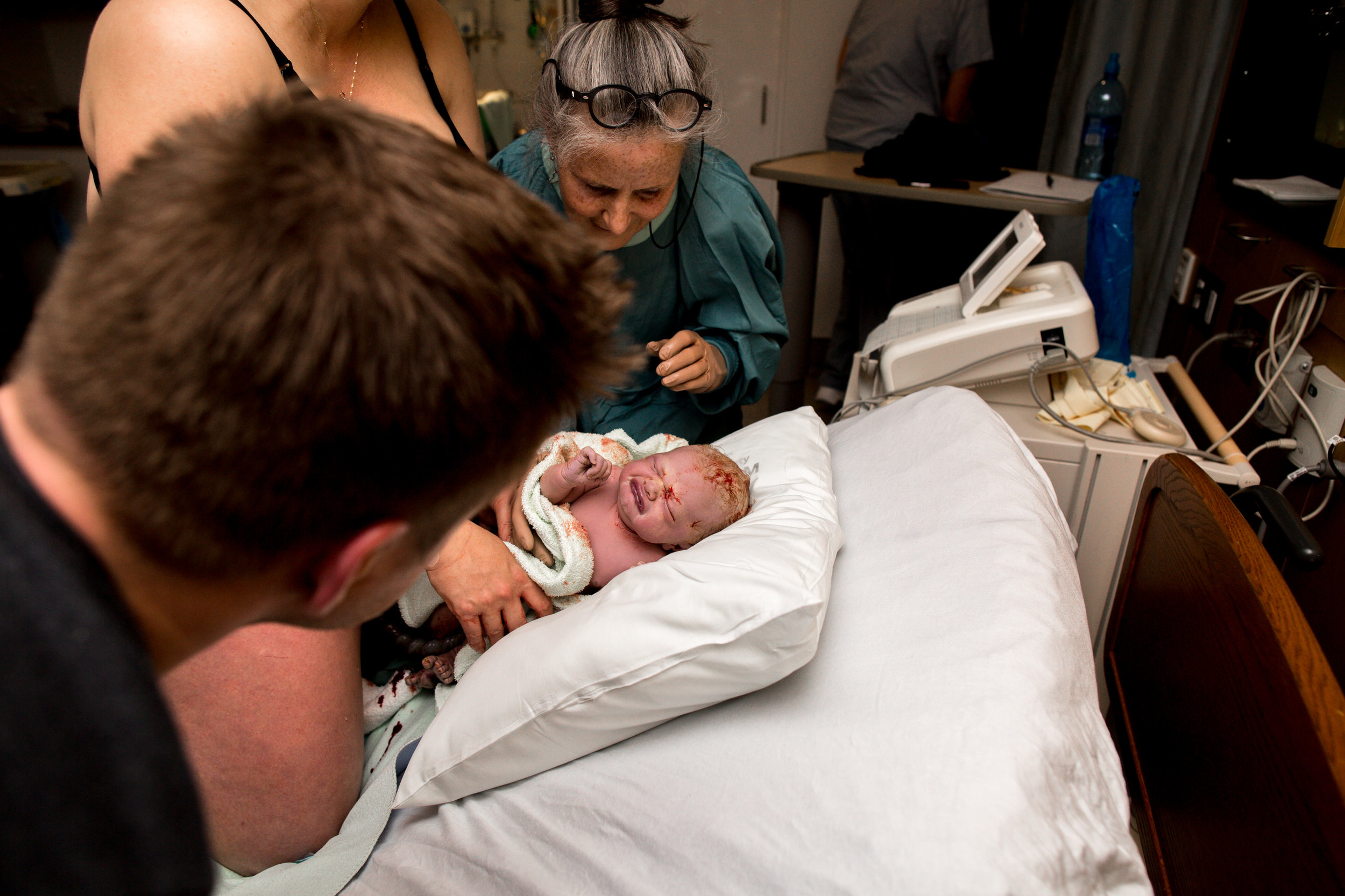 midwife with baby right after hospital birth on bed