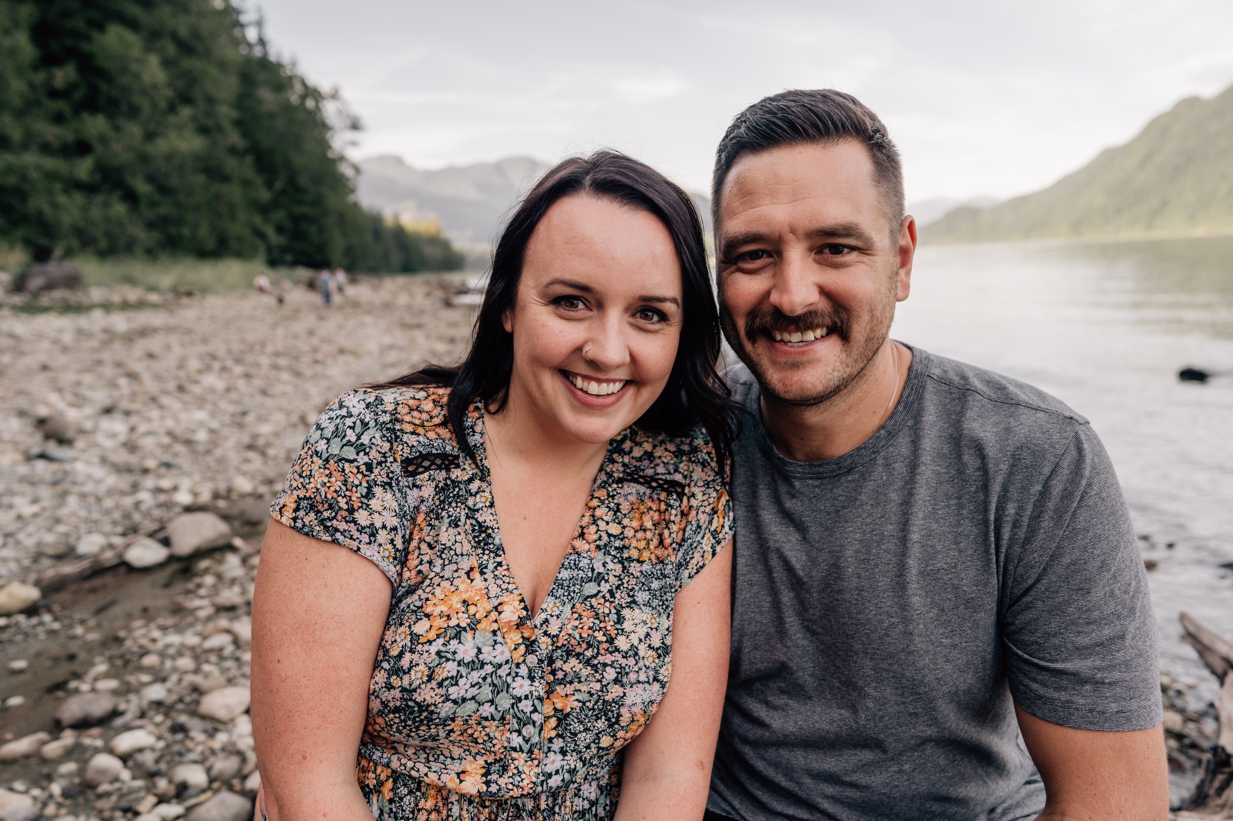 parents portrait with kids in the background beside water