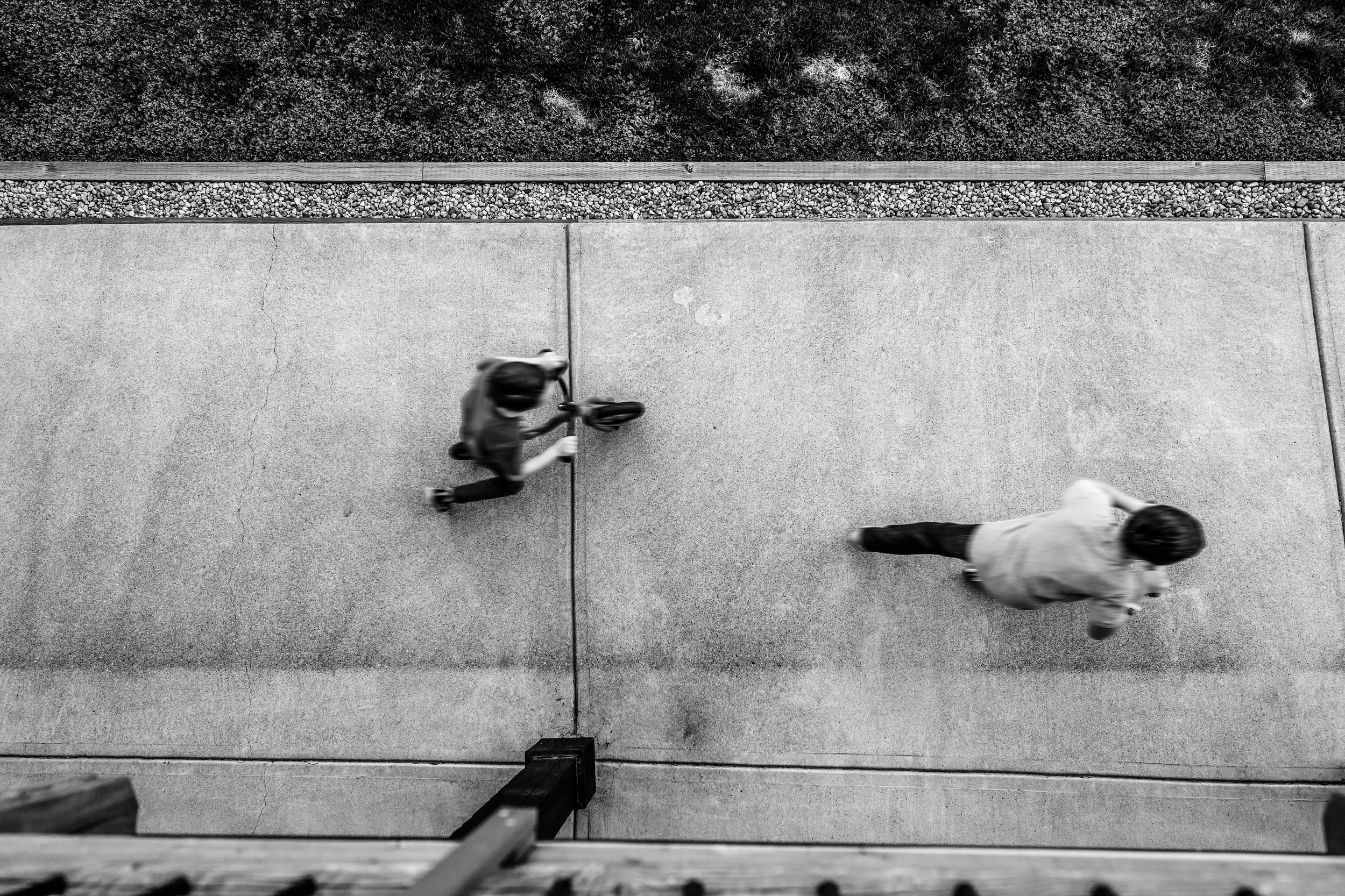 black and white kids riding bikes fast from above in back yard