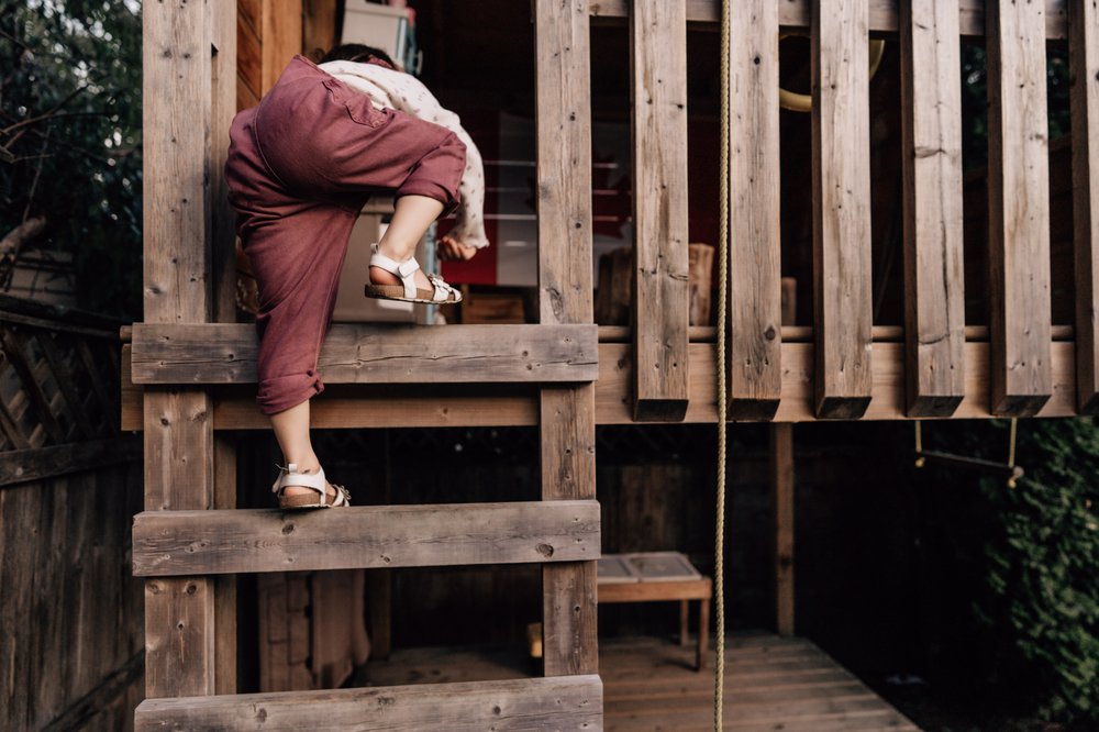 small girl child climbing up playhouse ladder