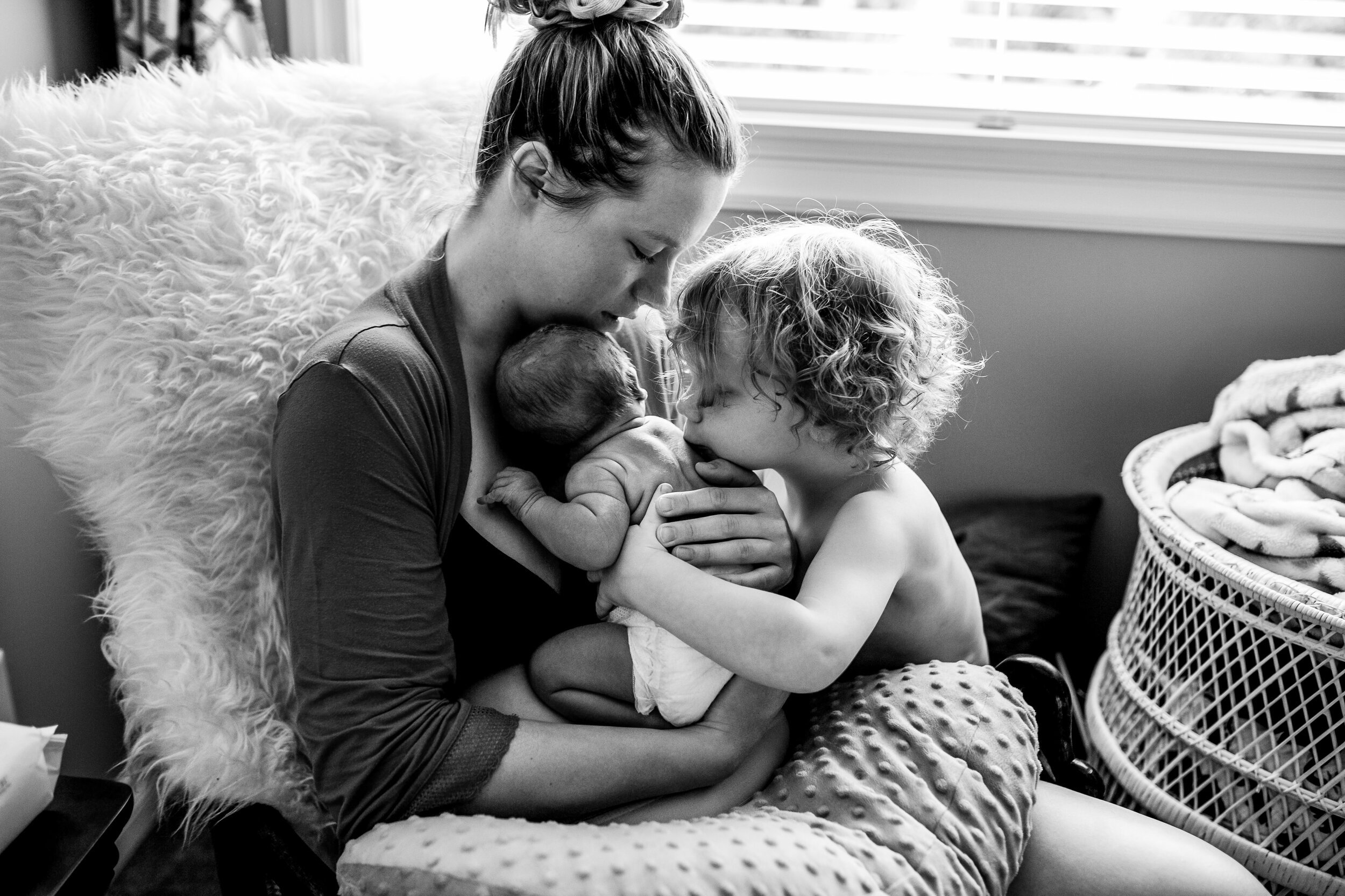 mom-toddler-newborn-hugging-by-window