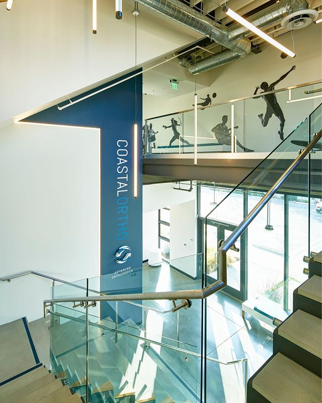 Coastal Ortho is an orthopedic doctors office in El Segundo completed last year. This image shows the staircase to the treatment rooms upstairs with imagery of sporting activities to emphasize wellness.