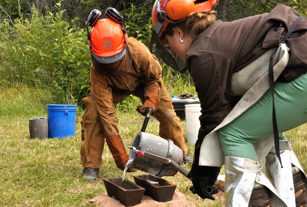 Liz Ensz and Morgan Herum pouring aluminum ingots