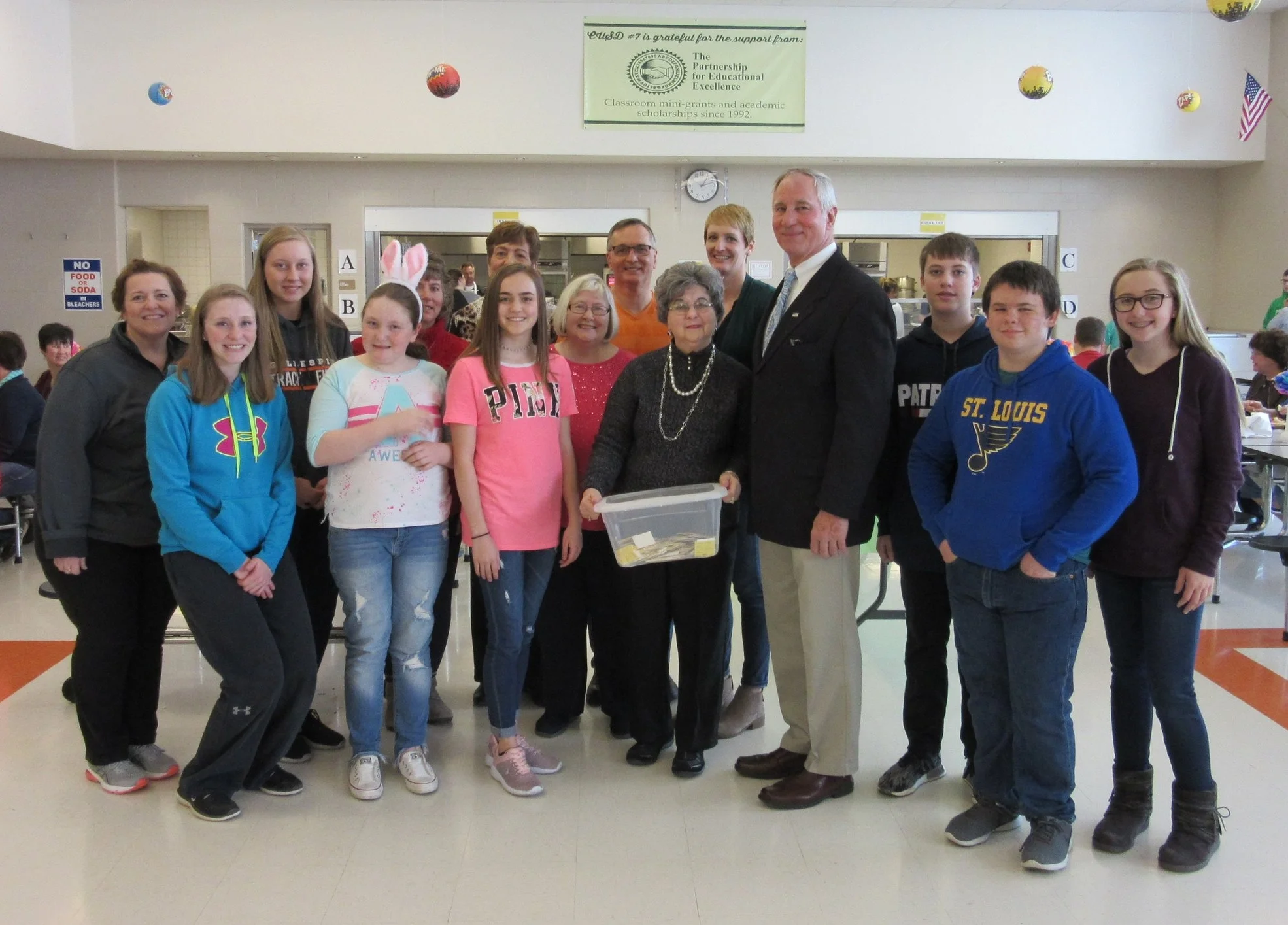 It's all about the students! Gathered for the drawing were BGES principal (far left) Angela Sandretto, student volunteers, and Partnership directors: (left to right) Angela Sandretto, Ally Clay, Jaiden Braundmeier, Maggie Heyen, Susan Stromsland, Carole Scheller behind "drawer" Megan Hatlee, Nanci Grandone, Don Throne, Rose Tebbe, Katie Ronald, John Fassero, Cameron Link, Josh Ranger, and Jenna Clark.