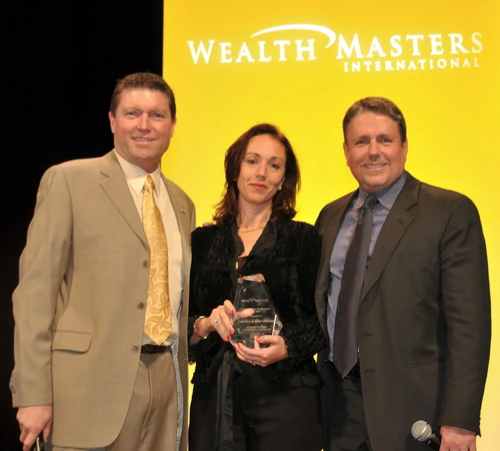 Tanya receiving a Sales & Leadership award from Wealth Masters International Founders, Karl Bessey & Kip Herriage