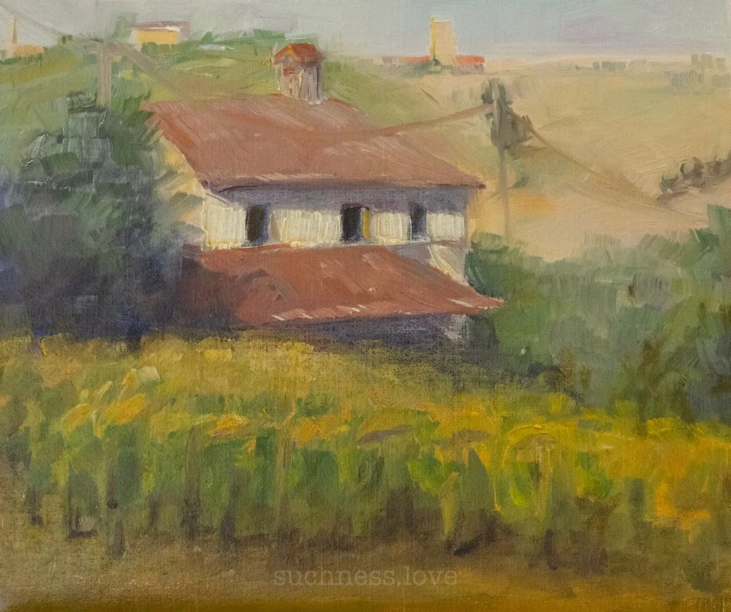 A watercolor painting of a house with a red roof, set in a lush, green landscape with hills and trees in the background.