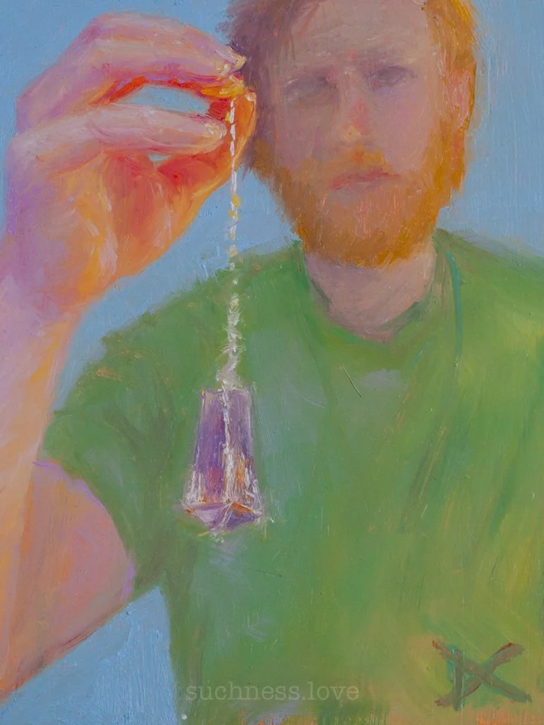 A person with red hair and a beard holding a small hourglass. The person is wearing a green shirt, and the background is a light blue color.