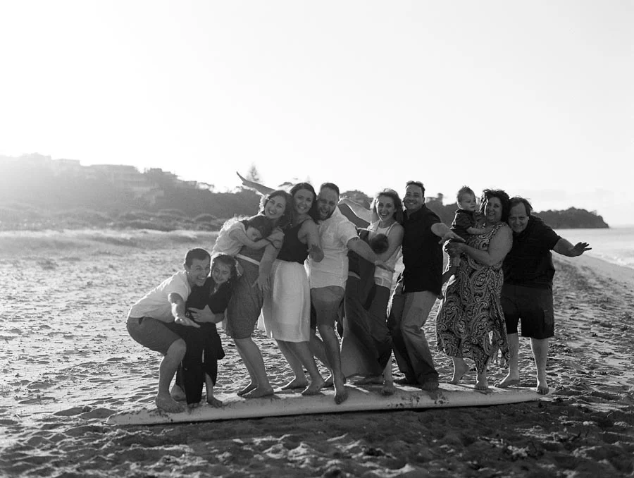 A fun photograph of an extended family on a surfboard at a Mornington Peninsula beach.jpg