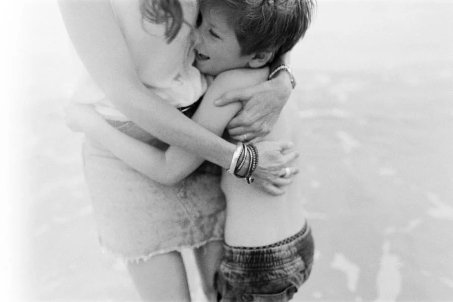 Film photograph of a mother hugging and holding her son close on a beach.jpg