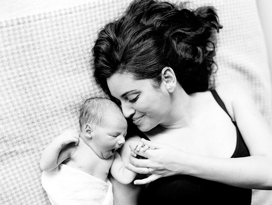 Film photograph of mum with newborn in Melbourne lying on a bed .jpg