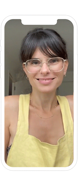 Jillian Turecki speaking to phone camera, wearing a yellow top and smiling.