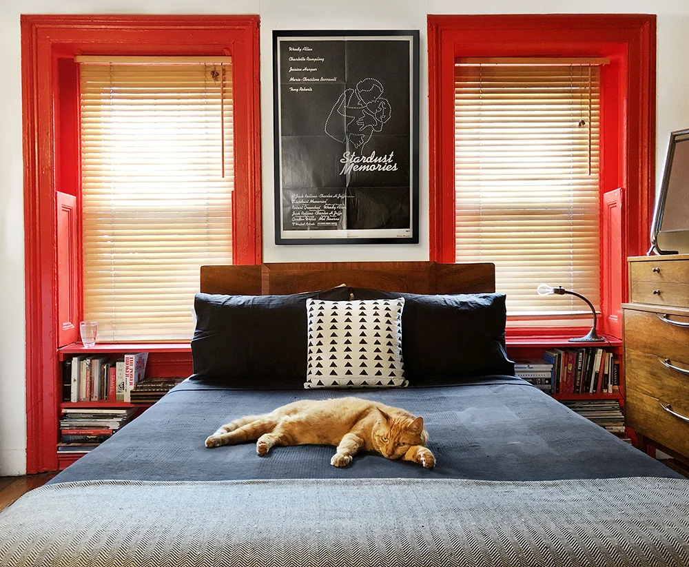 1930's Art Deco bed frame, custom red shelves, vintage film poster and original lamp by local artisan. 
