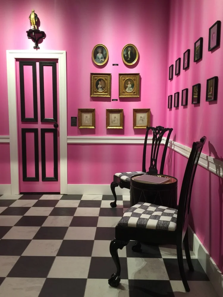 Elle Shushan's booth appeared to have a Dorothy Draper edge. Painted black antique chairs were placed on a black and white floor and black and gilt wood framed paintings and photographs decorated the pretty pink walls.