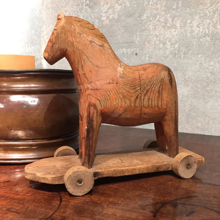 Once a play toy, this carved wooden horse would make a great decorative accessory in a family room or library. 