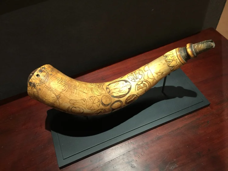 A folk art engraved powder horn featuring unusually relief carved geometric forms, king's head, tree of life and rabbit's head from 1732 was shown by Nathan Liverant and Son, LLC.