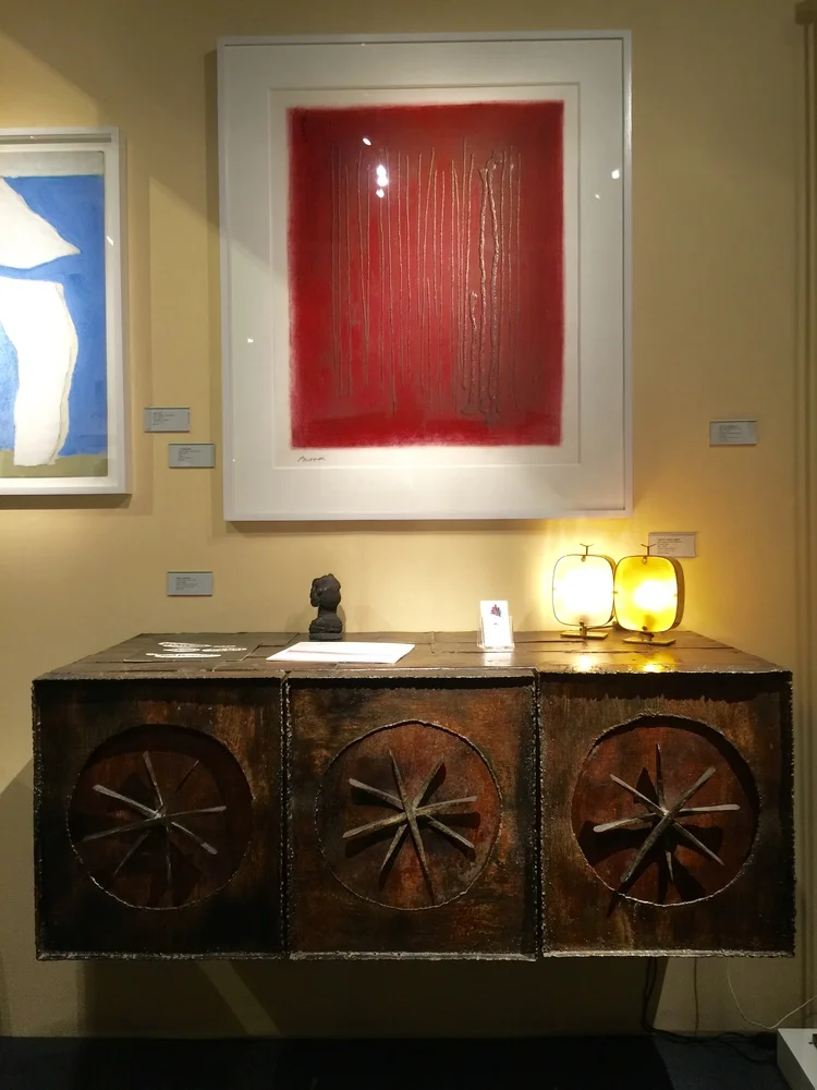 This captivating wall cabinet by Paul Evans is crafted of steel, gilt wood and bronze.  The red vertical striations in the lithograph by Adja Yunkers are a perfectly compliment to the brutalist piece.