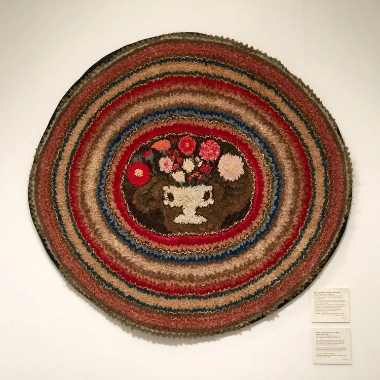 An extraordinary circular shirred rug with a stylized urn of flowers, circa 1840, was displayed by Frank & Barbara Pollack American Antiques & Art.